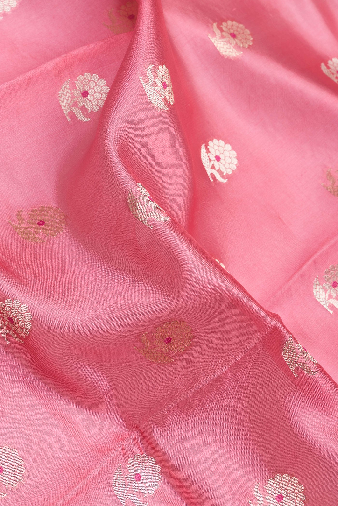 Close up of Rose Gold and Peach Dual Tone Banarasi Raw Silk Saree with Zari Butta on the body and Zari Border.  displaying folds