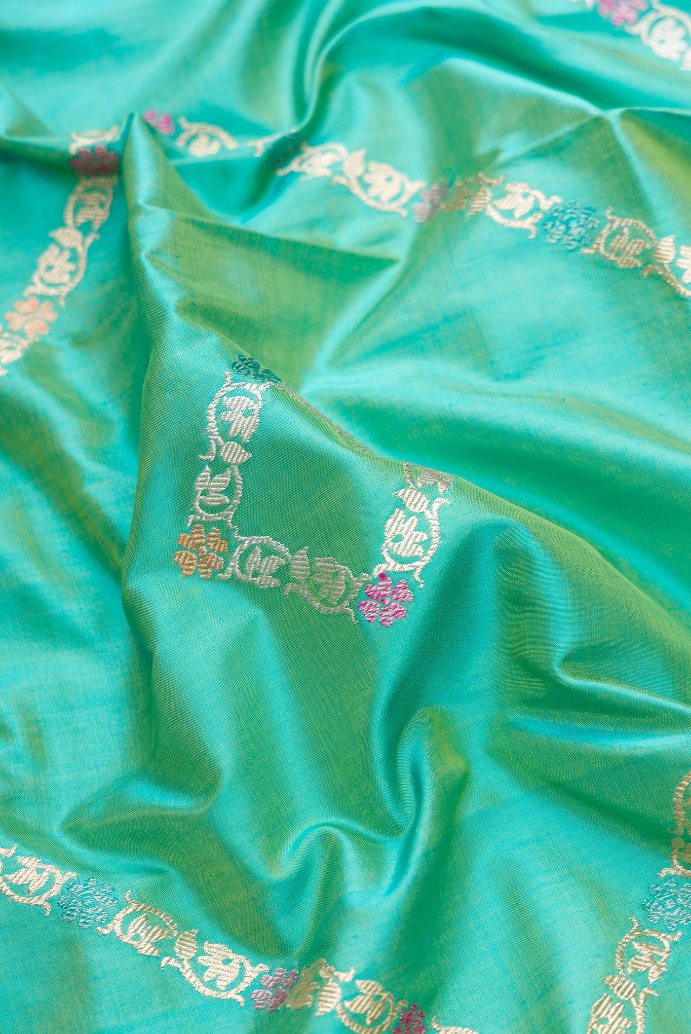 Close up of Sea Green Dual Tone Banarasi Silk Saree with Stripes on the body and Zari Border.  displaying folds