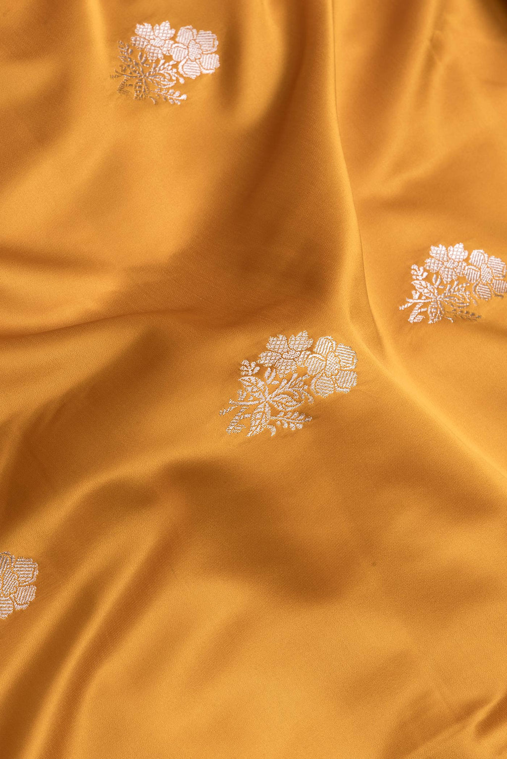 Close up of Yellow Dual Tone Banarasi Silk Saree with Zari Butta on the body and Zari Border.  displaying folds