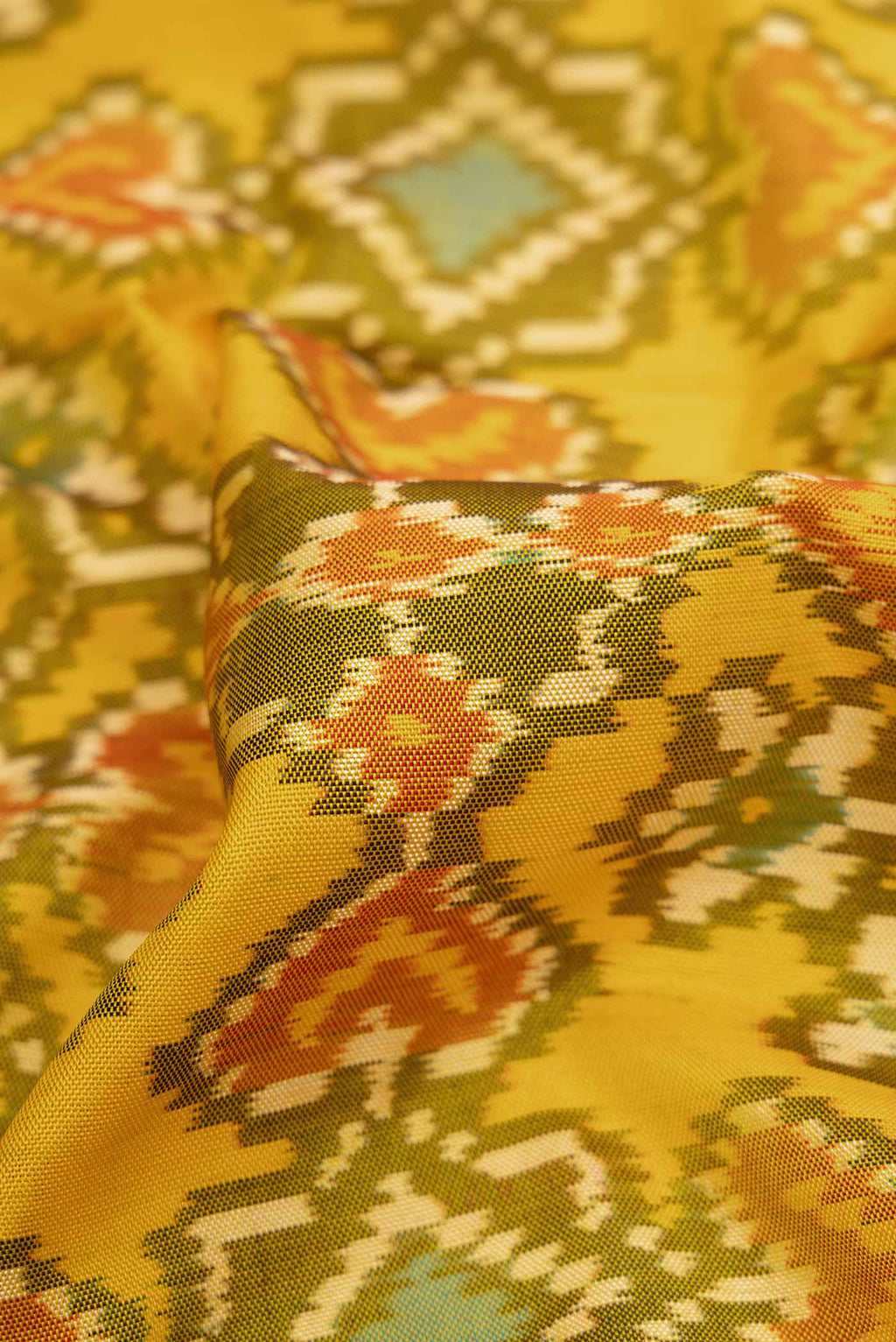 Close up of Yellow Dual Tone Rajkot Patola Silk Saree with Ikat Print on the body and Ikat Border displaying folds
