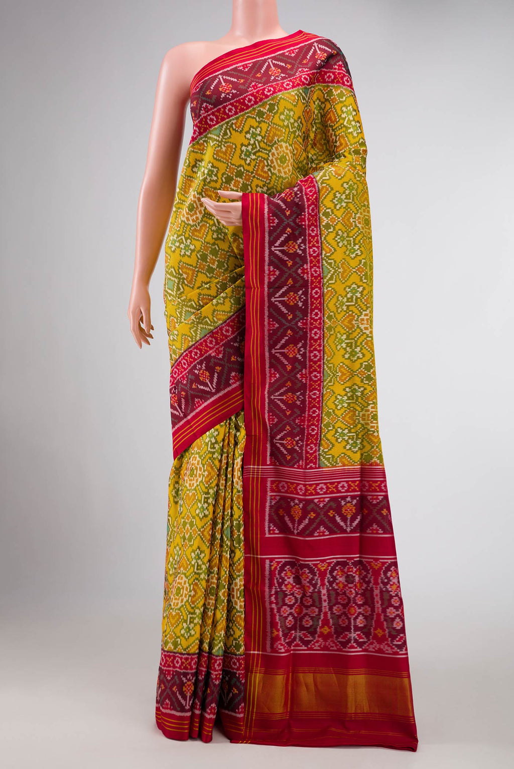 Yellow Dual Tone Rajkot Patola Silk Saree with Ikat Print on the body and Ikat Border displayed on a mannequin