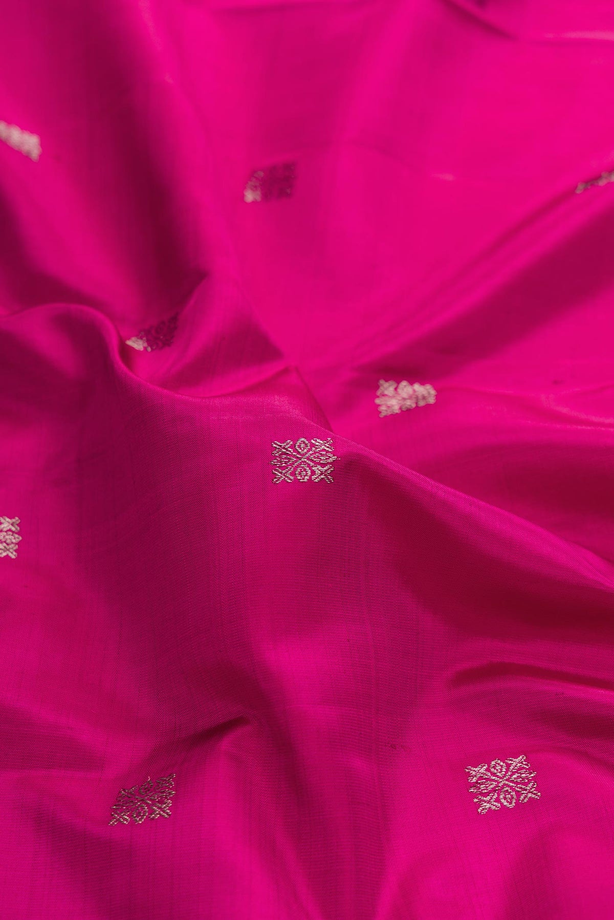 Close up of Magenta Dual Tone Kanchipuram Silk Saree with Zari Butta on the body and Zari Border displaying folds
