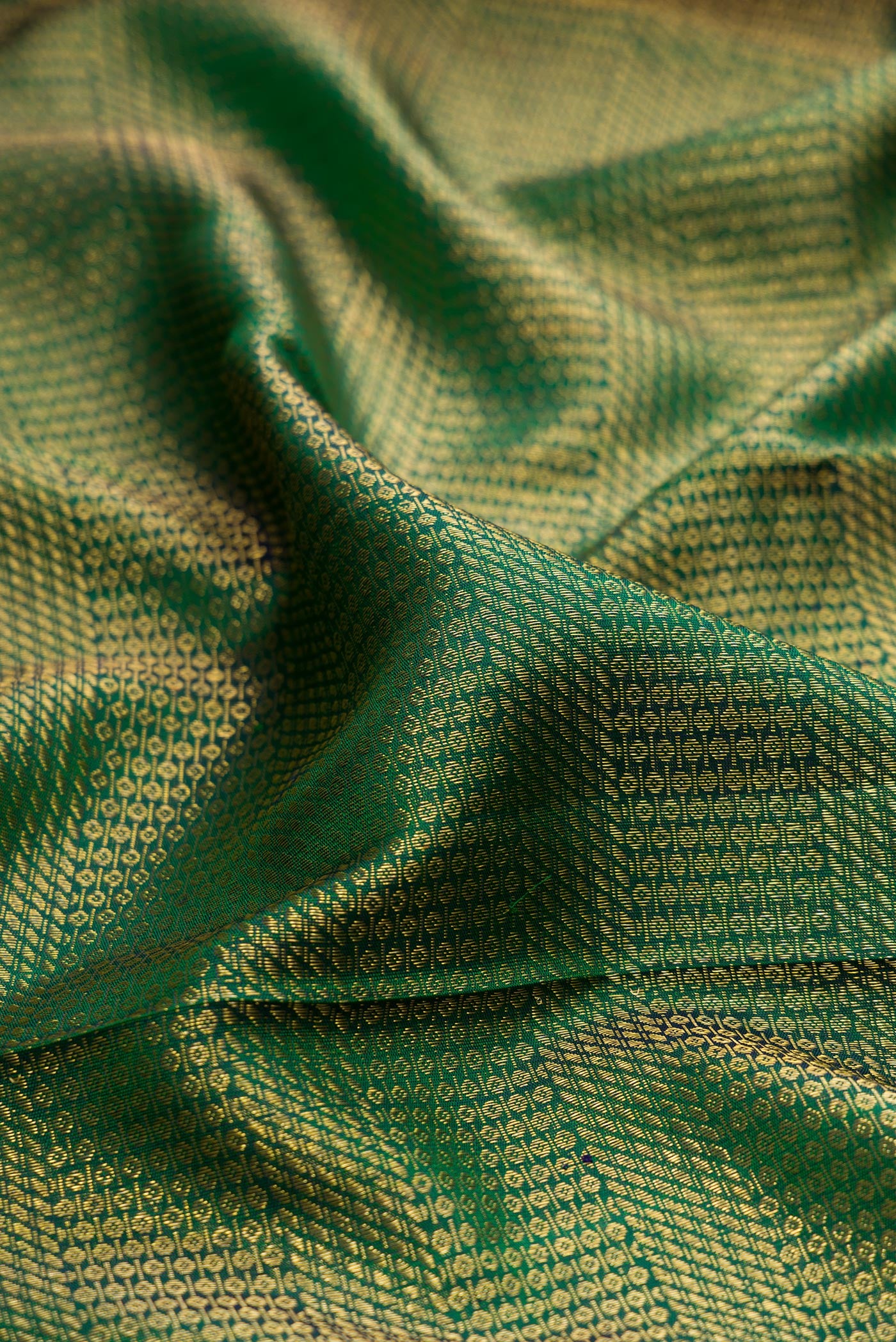 Close up of Bottle Green Kanchipuram Silk Saree with Zari Brocade on the body and Fancy Border.  displaying folds
