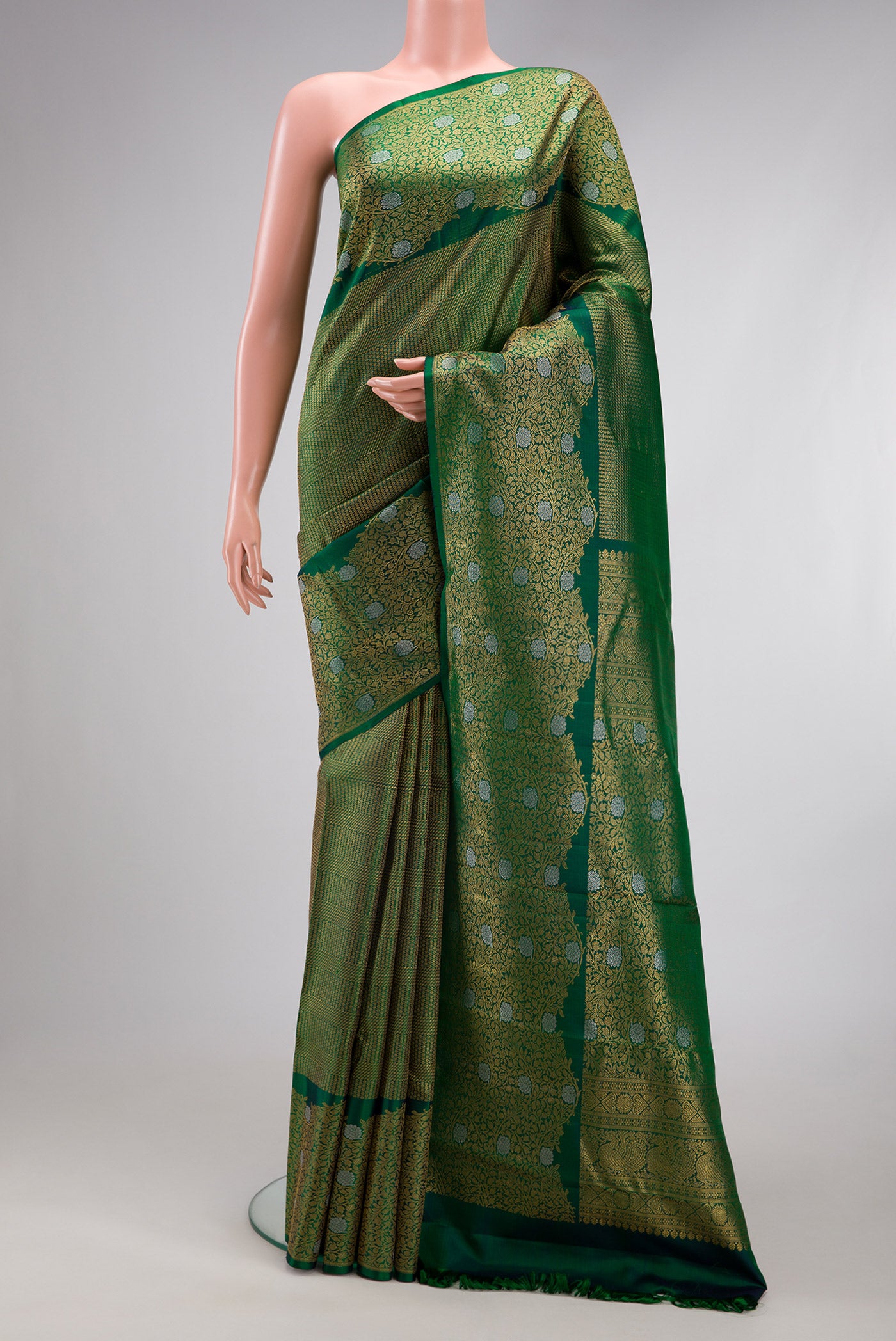 Bottle Green Kanchipuram Silk Saree with Zari Brocade on the body and Fancy Border.  displayed on a mannequin