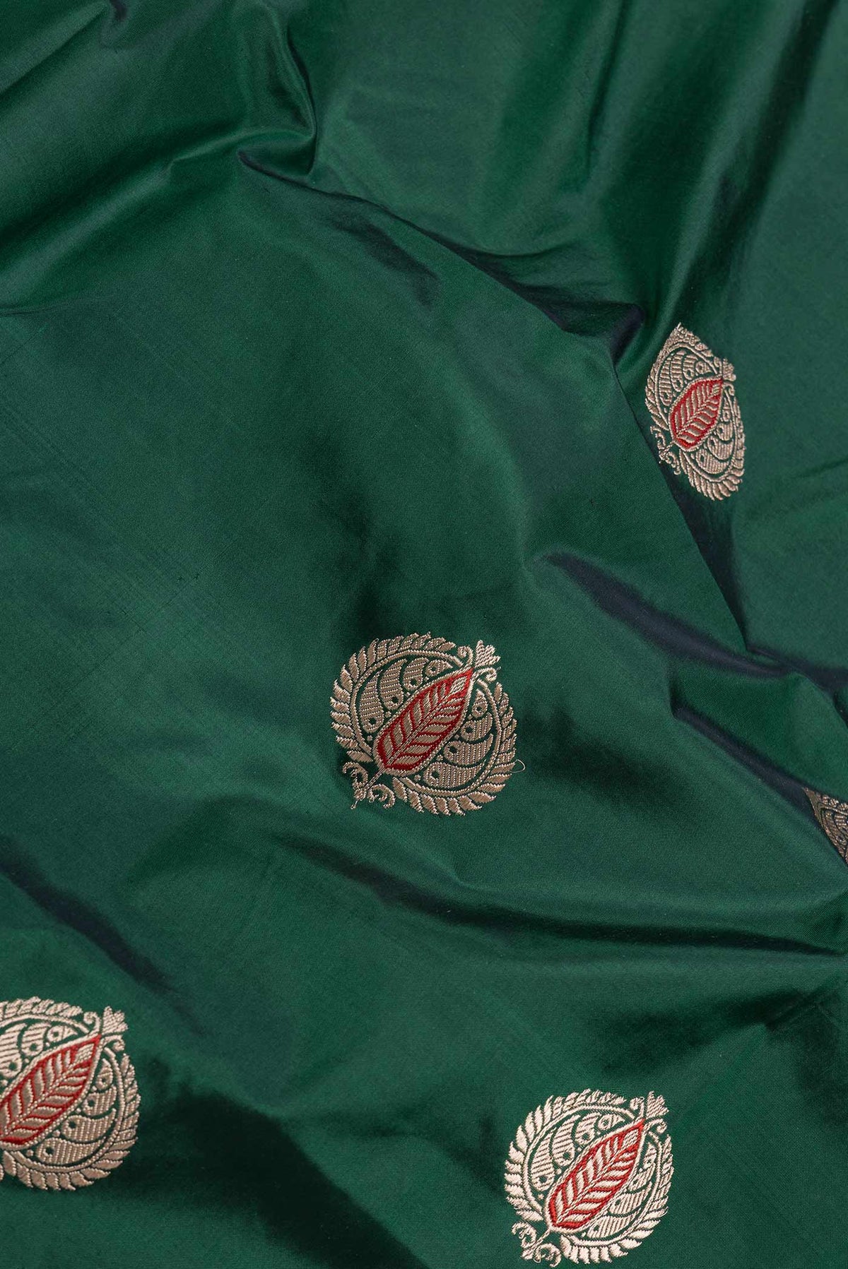 Close up of Bottle Green Dual Tone Banarasi Silk Saree with Zari And Thread Butta on the body and Zari Border displaying folds