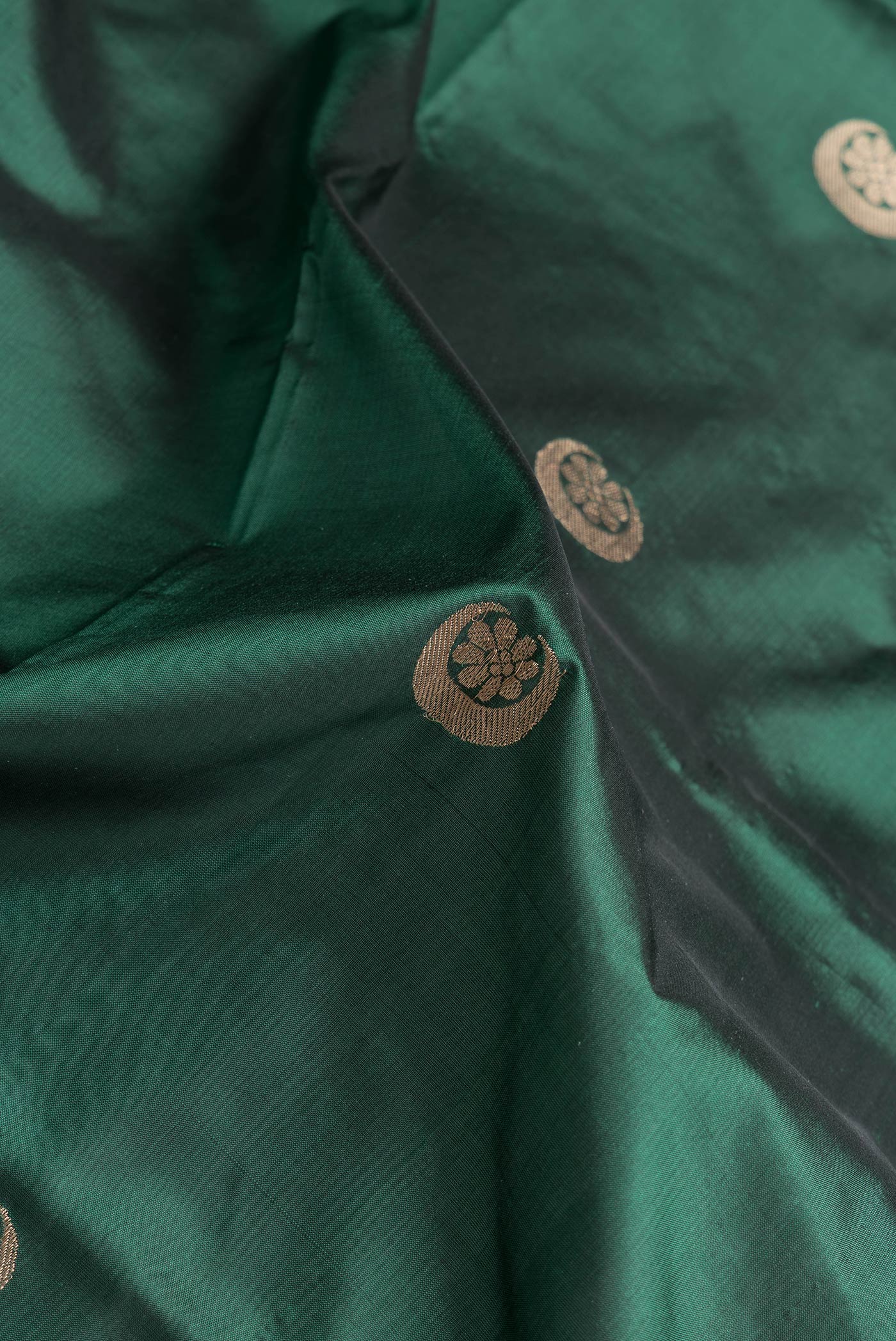 Close up of Bottle Green Dual Tone Banarasi Silk Saree with Zari Butta on the body and Zari Border.  displaying folds