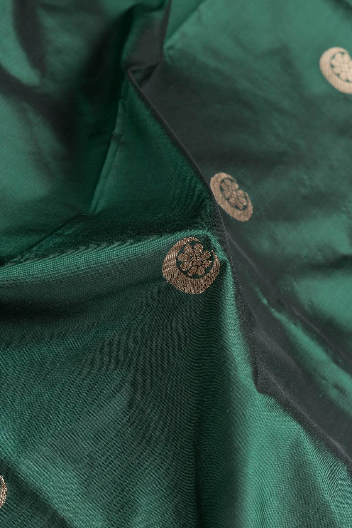 Close up of Bottle Green Dual Tone Banarasi Silk Saree with Zari Butta on the body and Zari Border.  displaying folds