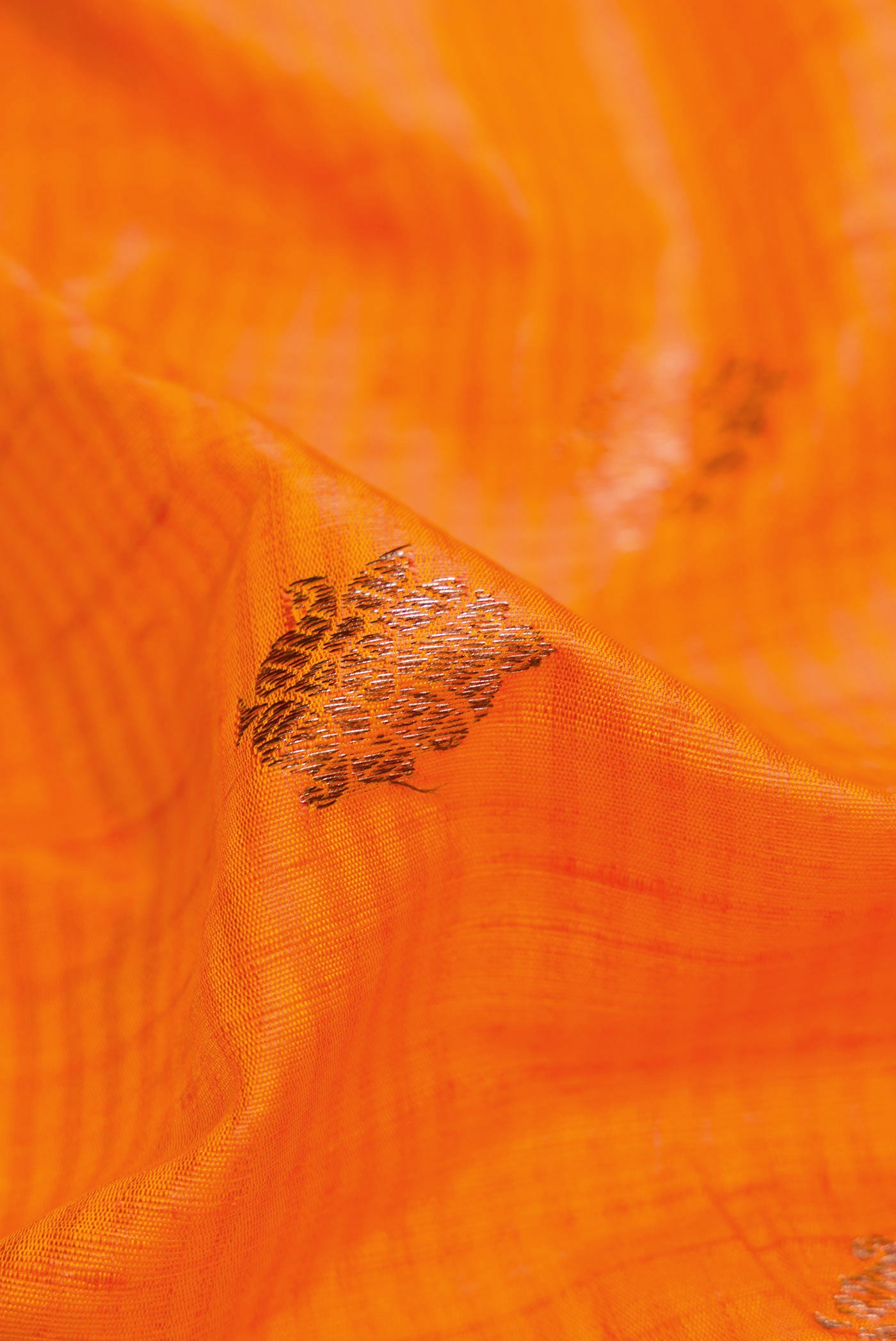 Close up of Orange Banarasi Tussar Silk Saree with Zari Butta on the body and Zari Border displaying folds