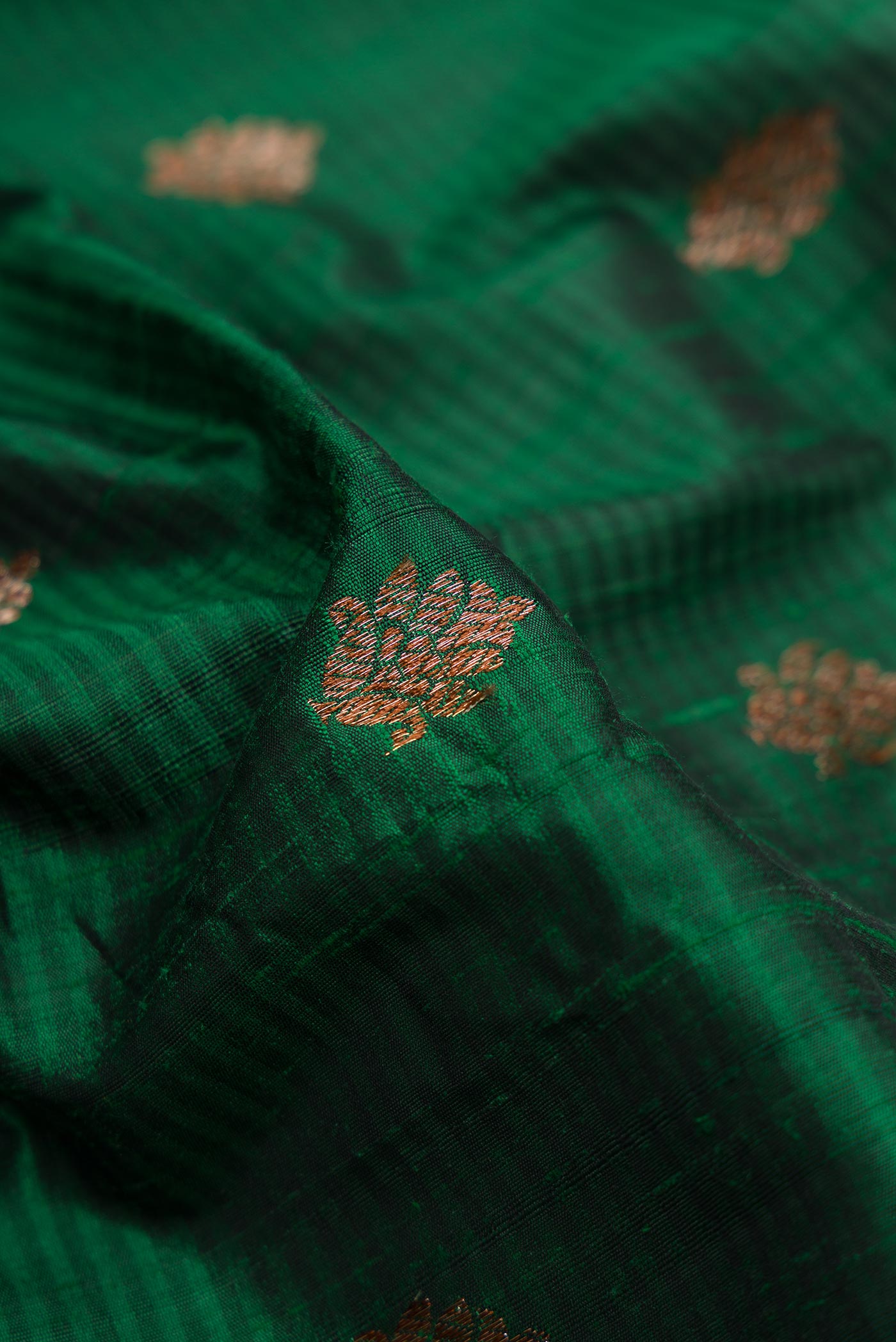 Close up of Bottle Green Banarasi Tussar Silk Saree with Zari Butta on the body and Zari Border displaying folds