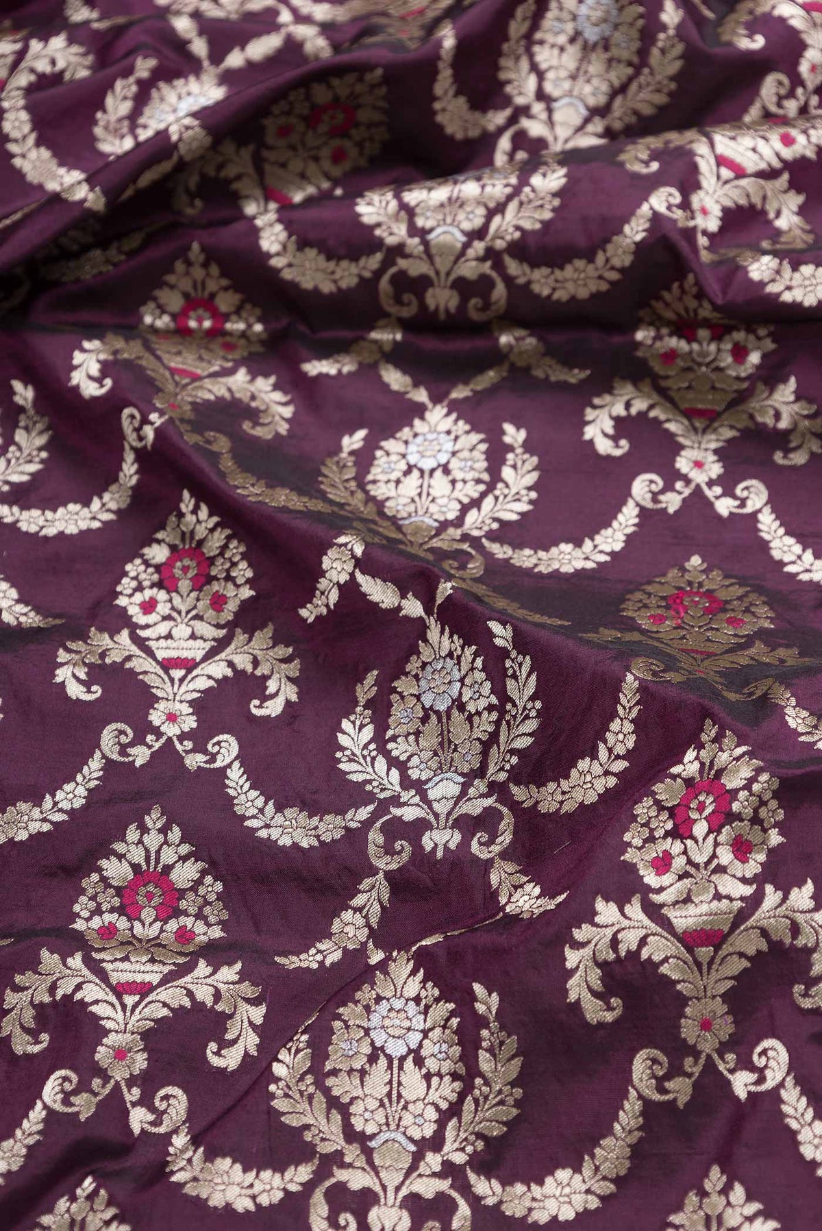 Close up of Burgundy Dual Tone Banarasi Silk Saree with Zari Brocade on the body and Zari Border displaying folds