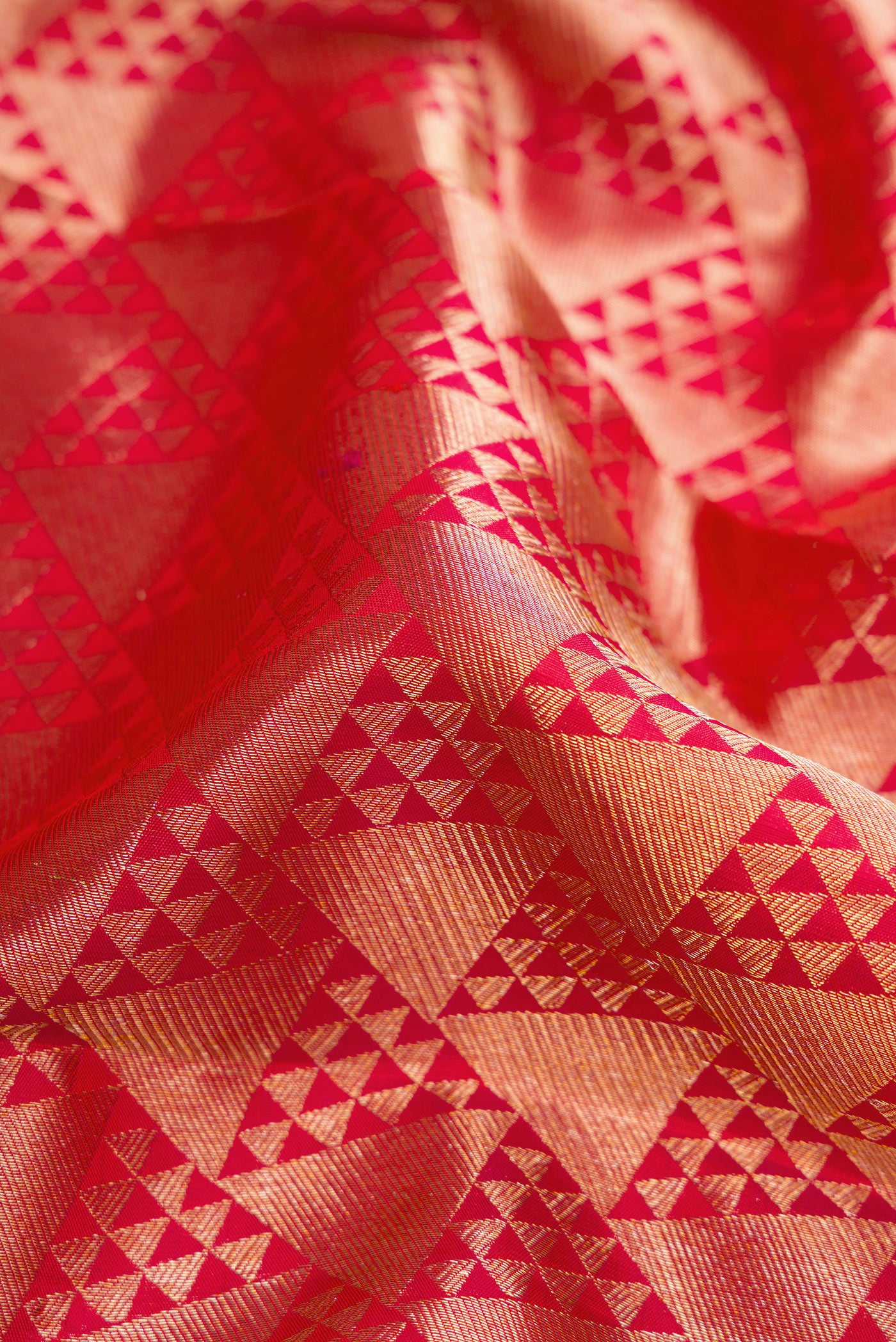 Close up of Red Dual Tone Kanchipuram Silk Saree with Zari Brocade on the body and Zari Border.  displaying folds