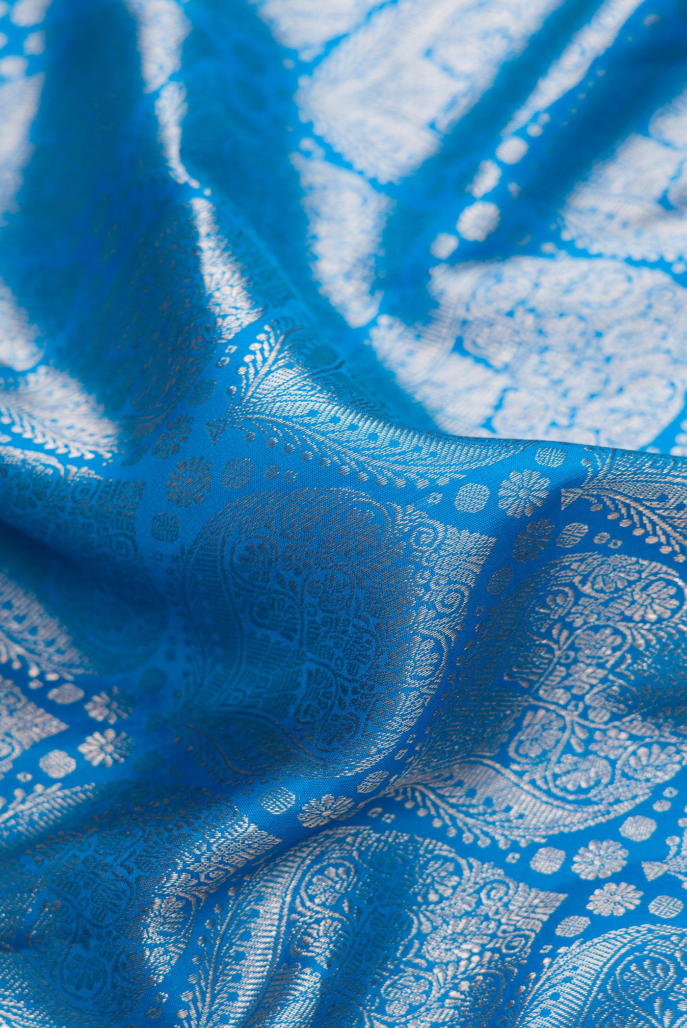 Close up of Sky Blue Dual Tone Kanchipuram Silk Saree with Zari Brocade on the body and Zari Border.  displaying folds