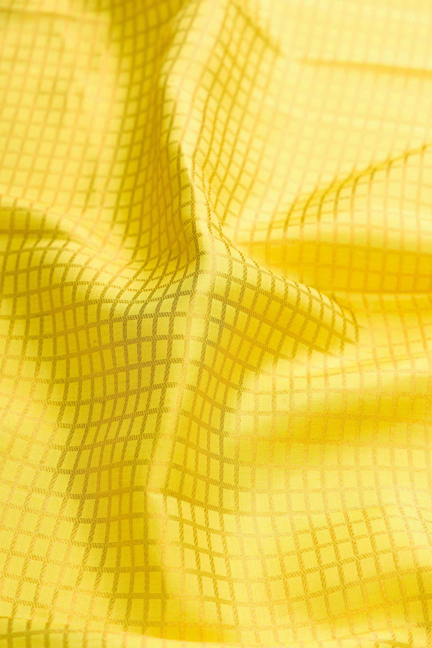 Close up of Yellow Dual Tone Kanchipuram Silk Saree with Checked design on the body and Zari Border displaying folds