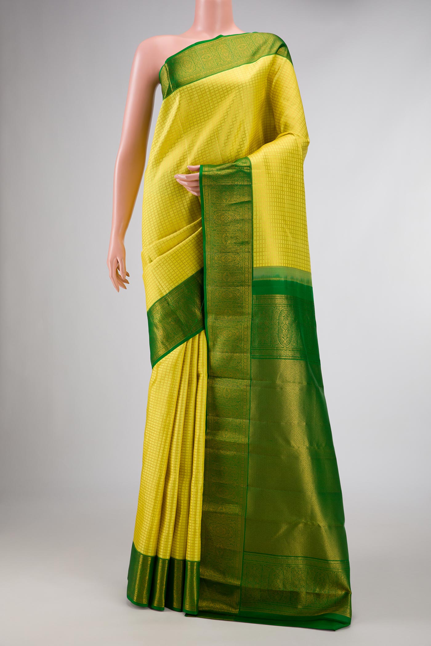 Yellow Dual Tone Kanchipuram Silk Saree with Checked design on the body and Zari Border displayed on a mannequin