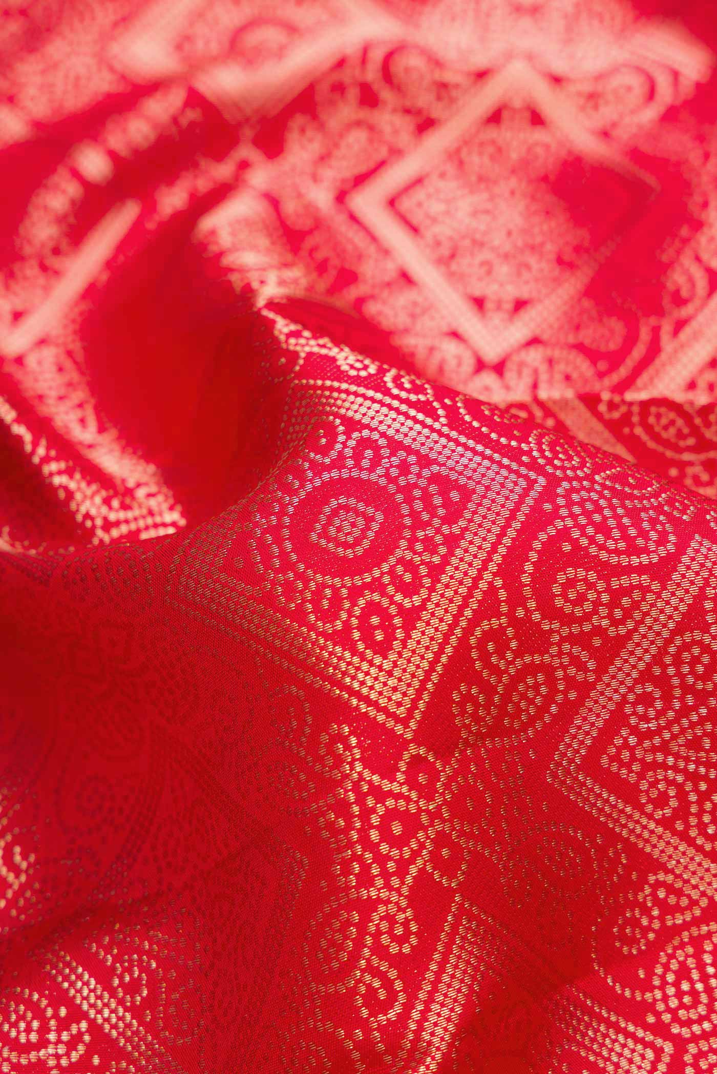 Close up of Red Dual Tone Kanjivaram Silk Saree with Zari Brocade on the body and Zari Border.  displaying folds
