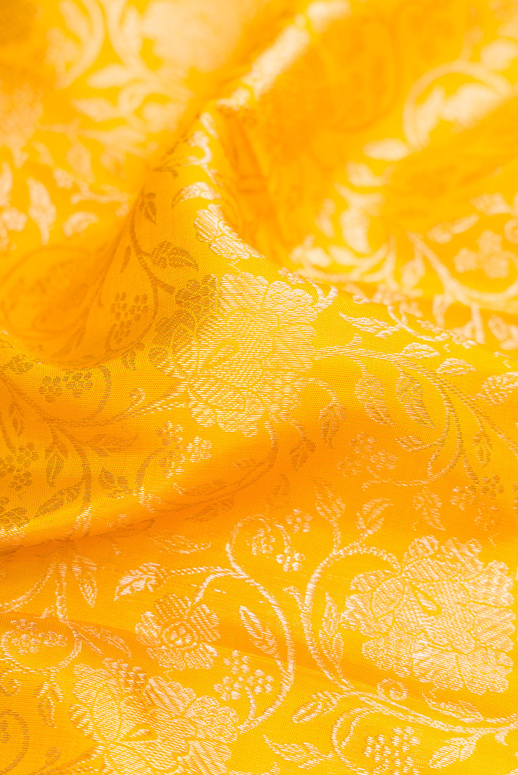 Close up of Yellow Dual Tone Kanchipuram Silk Saree with Zari Brocade on the body and Zari Border.  displaying folds