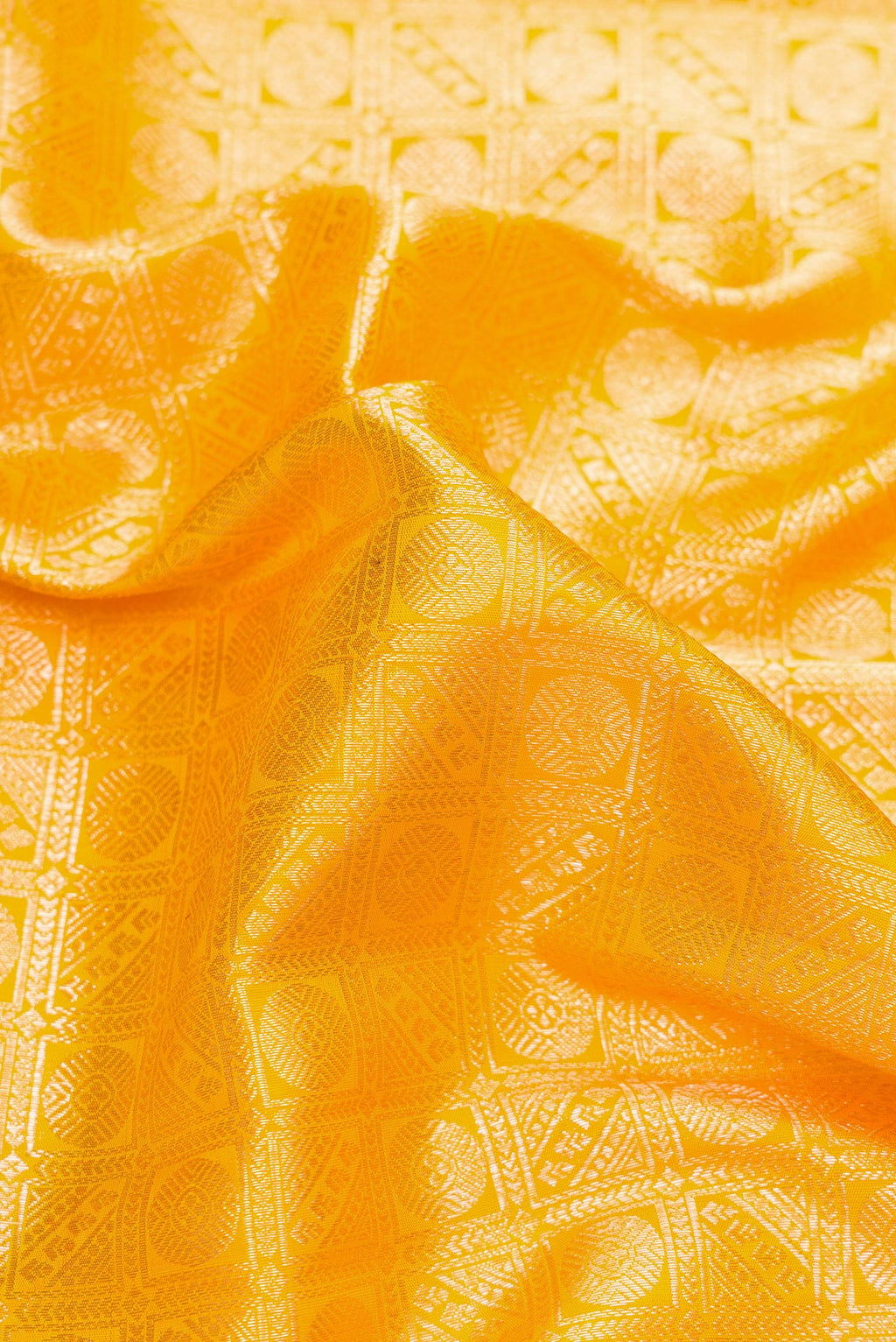 Close up of Yellow Dual Tone Kanchipuram Silk Saree with Zari Brocade on the body and Fancy Border.  displaying folds