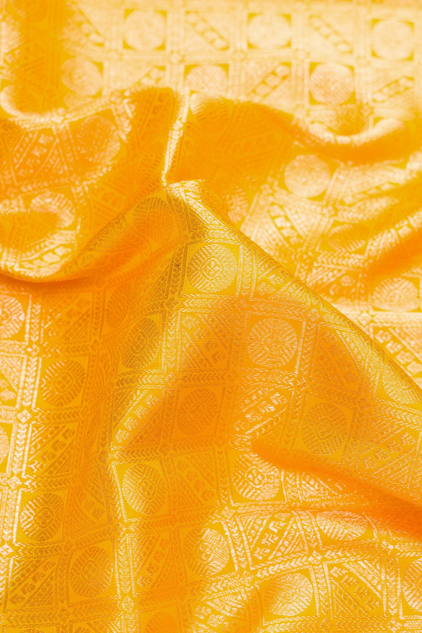 Close up of Yellow Dual Tone Kanchipuram Silk Saree with Zari Brocade on the body and Fancy Border.  displaying folds
