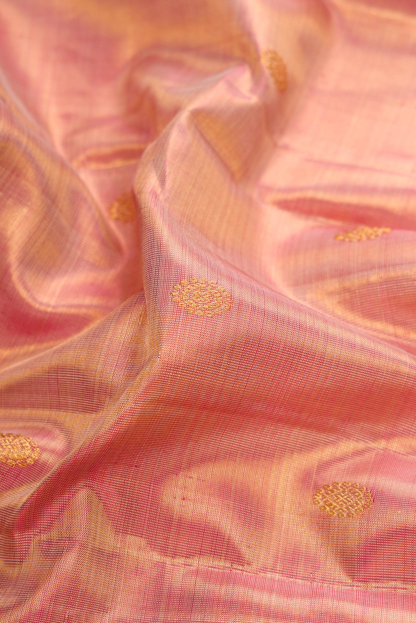 Close up of Rose Gold Dual Tone Kanchipuram Tissue Silk Saree with Zari Brocade on the body and Zari Border.  displaying folds