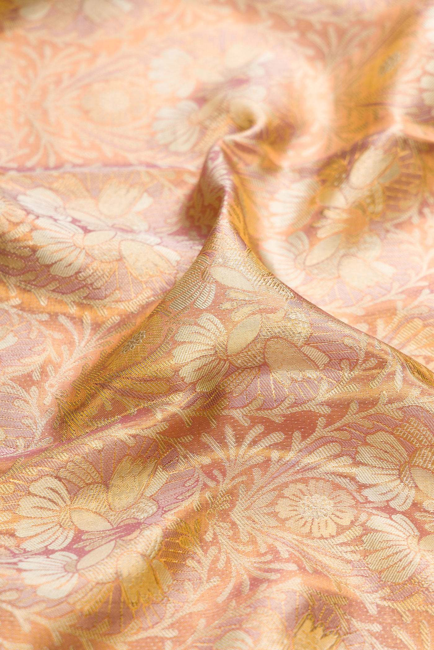 Close up of Rose Gold Dual Tone Kanchipuram Tissue Silk Saree with Zari Brocade on the body and Zari Border.  displaying folds