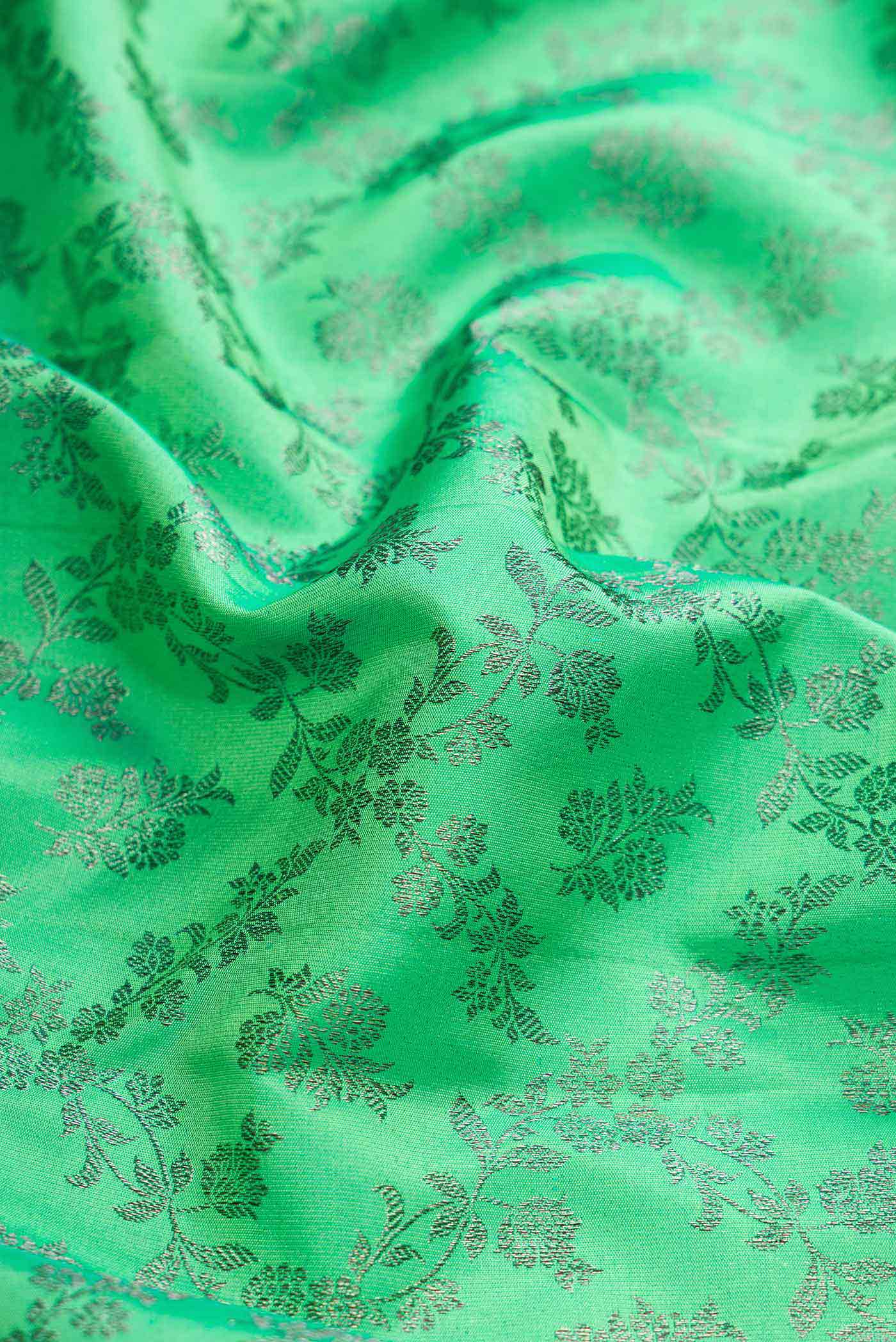 Close up of Green Dual Tone Kanchipuram Silk Saree with Zari Brocade on the body and Zari Border displaying folds