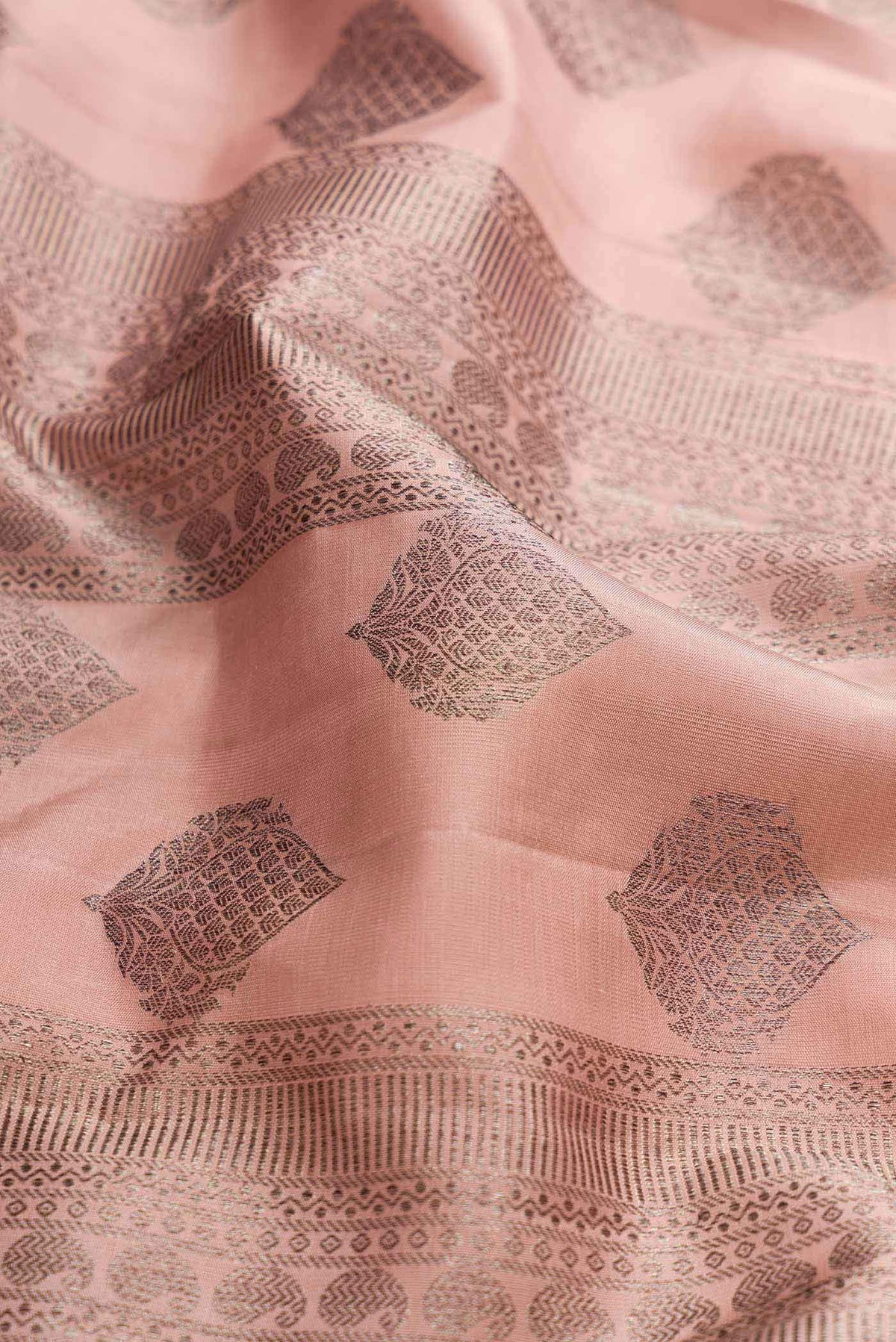 Close up of Golden Peach Dual Tone Kanchipuram Silk Saree with Zari Brocade on the body and Zari Border displaying folds