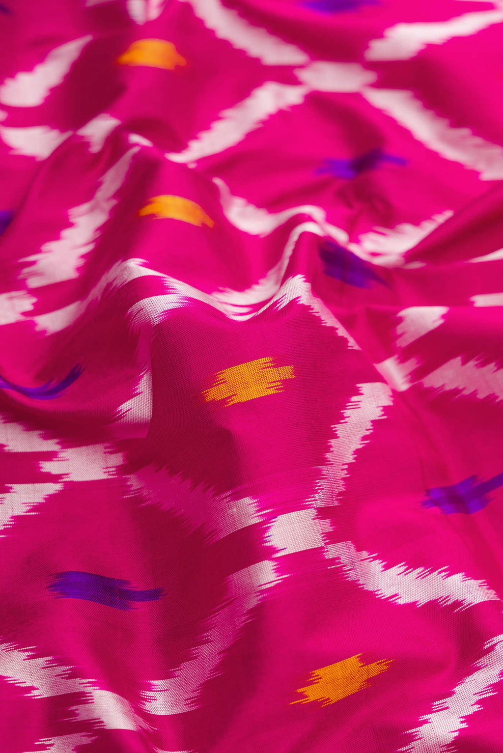Close up of Pink Dual Tone Double Ikat Saree with Ikat Print on the body and Ikat Border.  displaying folds