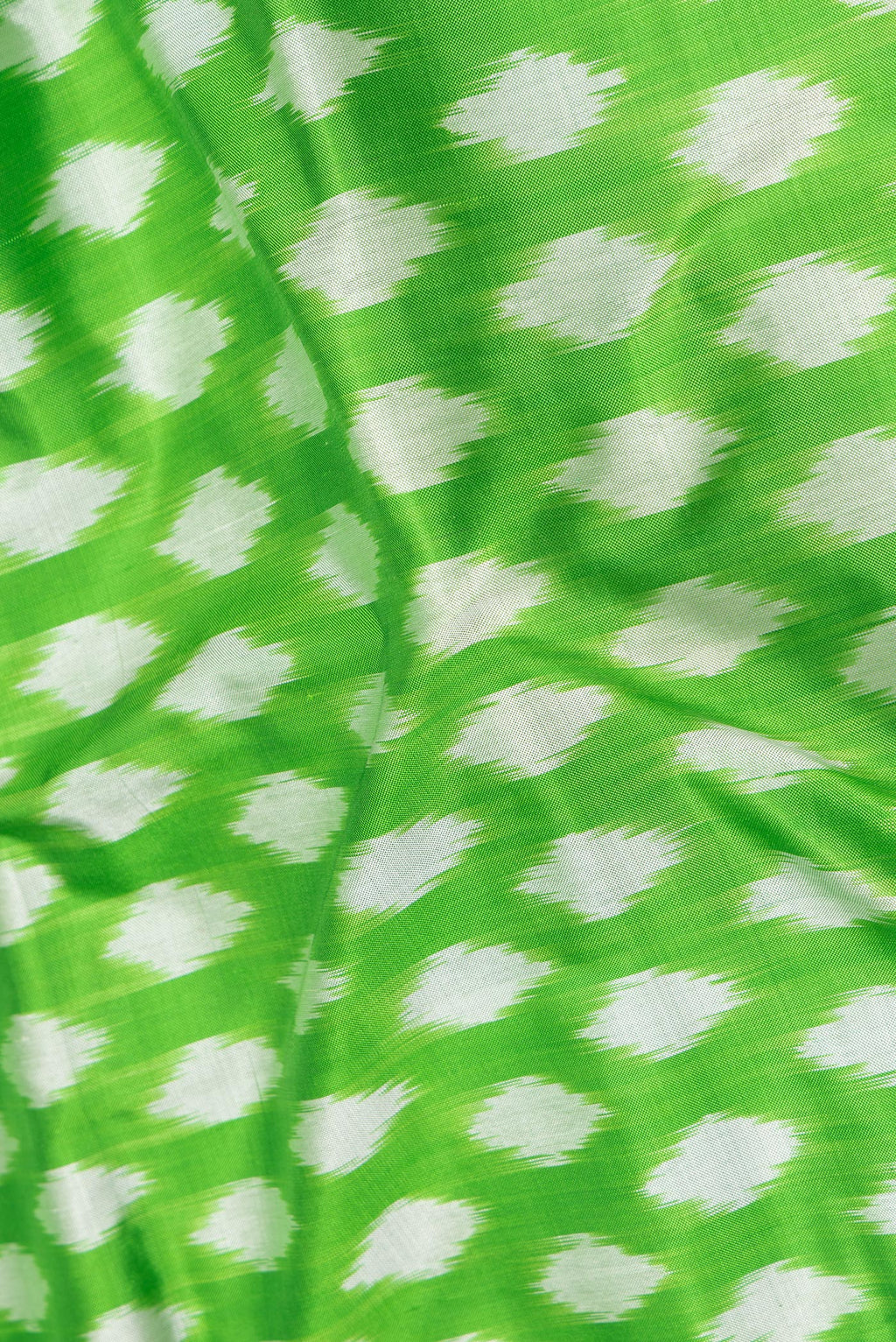 Close up of Pure Silk Parrot Green Dual Tone Pochampally Saree with Ikat design on the body and Ikat Border.  displaying folds