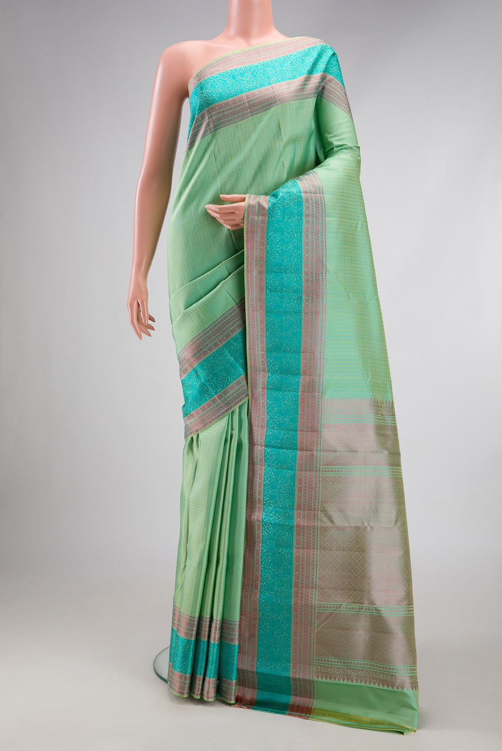 Mint Green Kanchipuram Silk Saree with Checked design on the body and Thread Border.  displayed on a mannequin