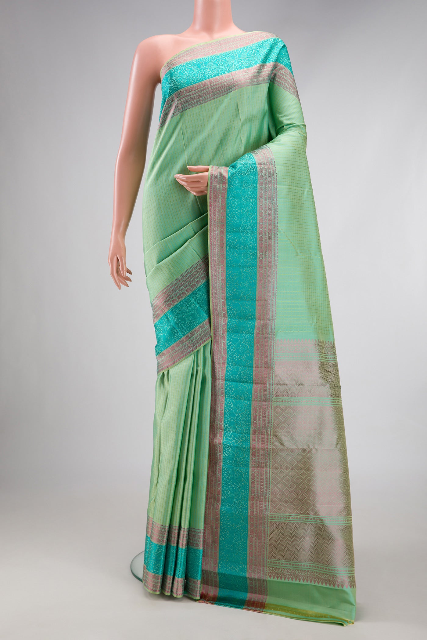 Mint Green Kanchipuram Silk Saree with Checked design on the body and Thread Border.  displayed on a mannequin