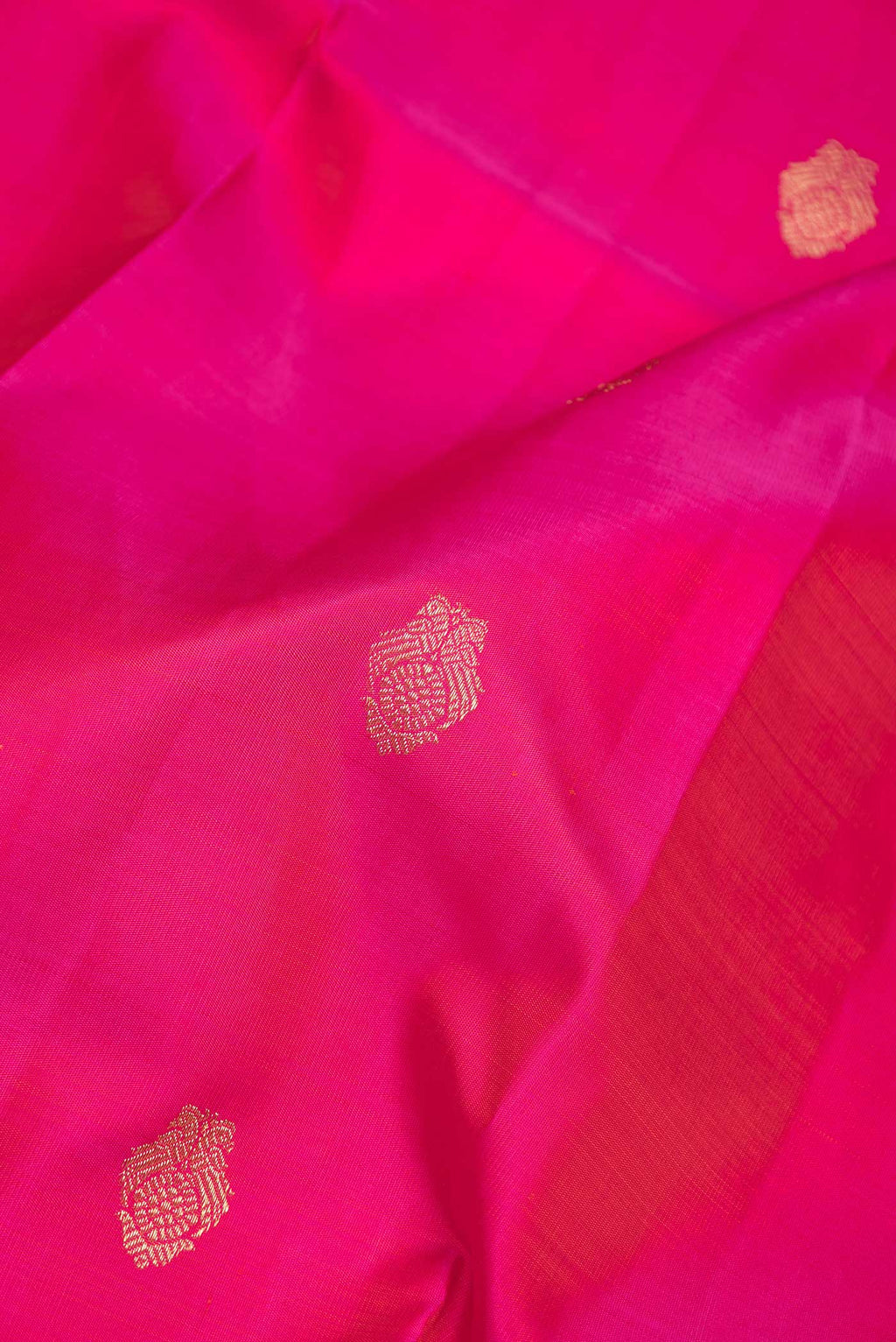 Close up of Pure Silk Pure Zari Dark Pink Dual Tone Kanchipuram Saree with Zari Butta on the body and Zari Border displaying folds