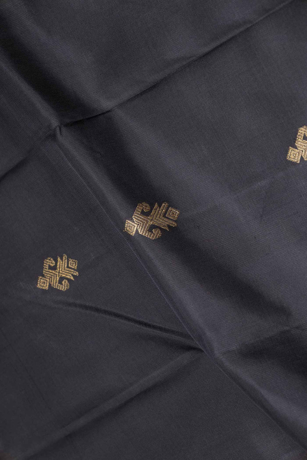 Close up of Pure Silk Pure Zari Black Dual Tone Kanchipuram Saree with Zari Butta on the body and Zari Border displaying folds