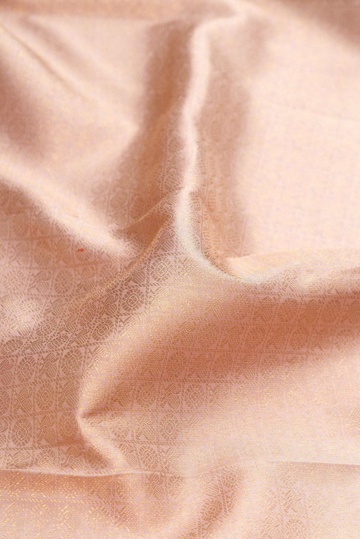 Close up of Pure Silk Pure Zari Rose Gold Dual Tone Kanjivaram Saree with Zari Brocade on the body and Zari Border.  displaying folds