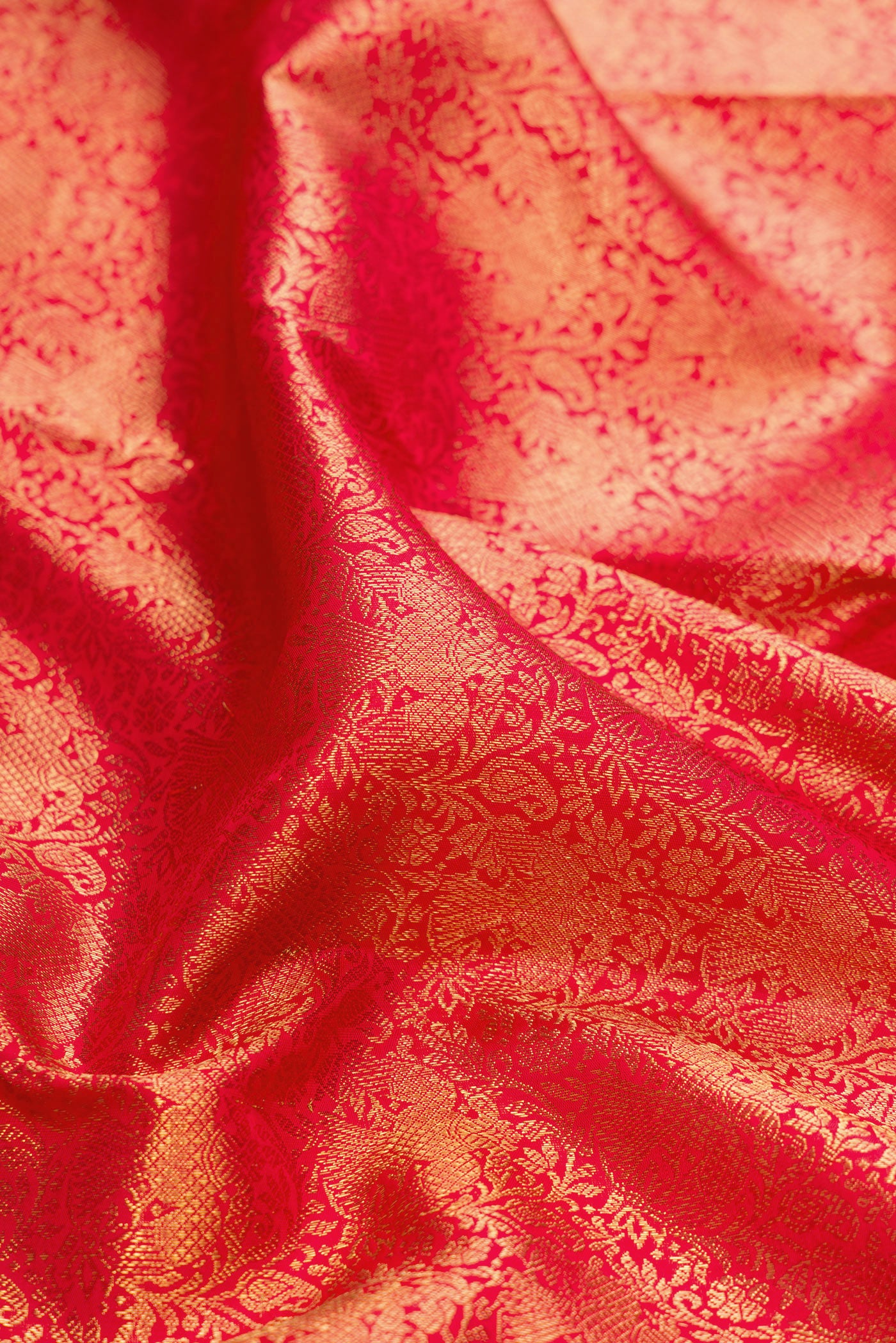 Close up of Pure Silk Pure Zari Red Dual Tone Kanjivaram Saree with Zari Brocade on the body and Zari Border.  displaying folds