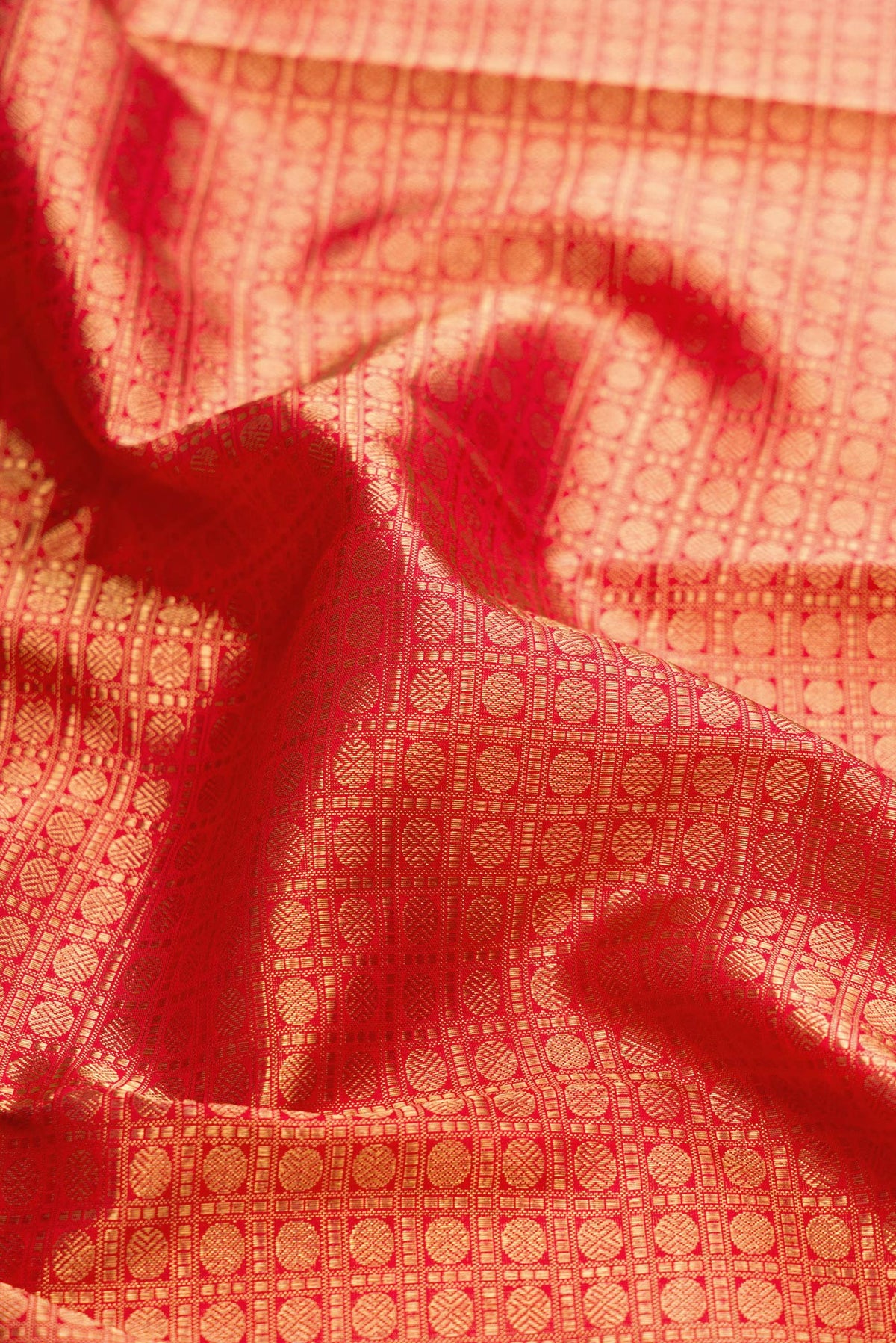 Close up of Pure Silk Pure Zari Red Dual Tone Kanjivaram Saree with Zari Brocade on the body and Zari Border.  displaying folds