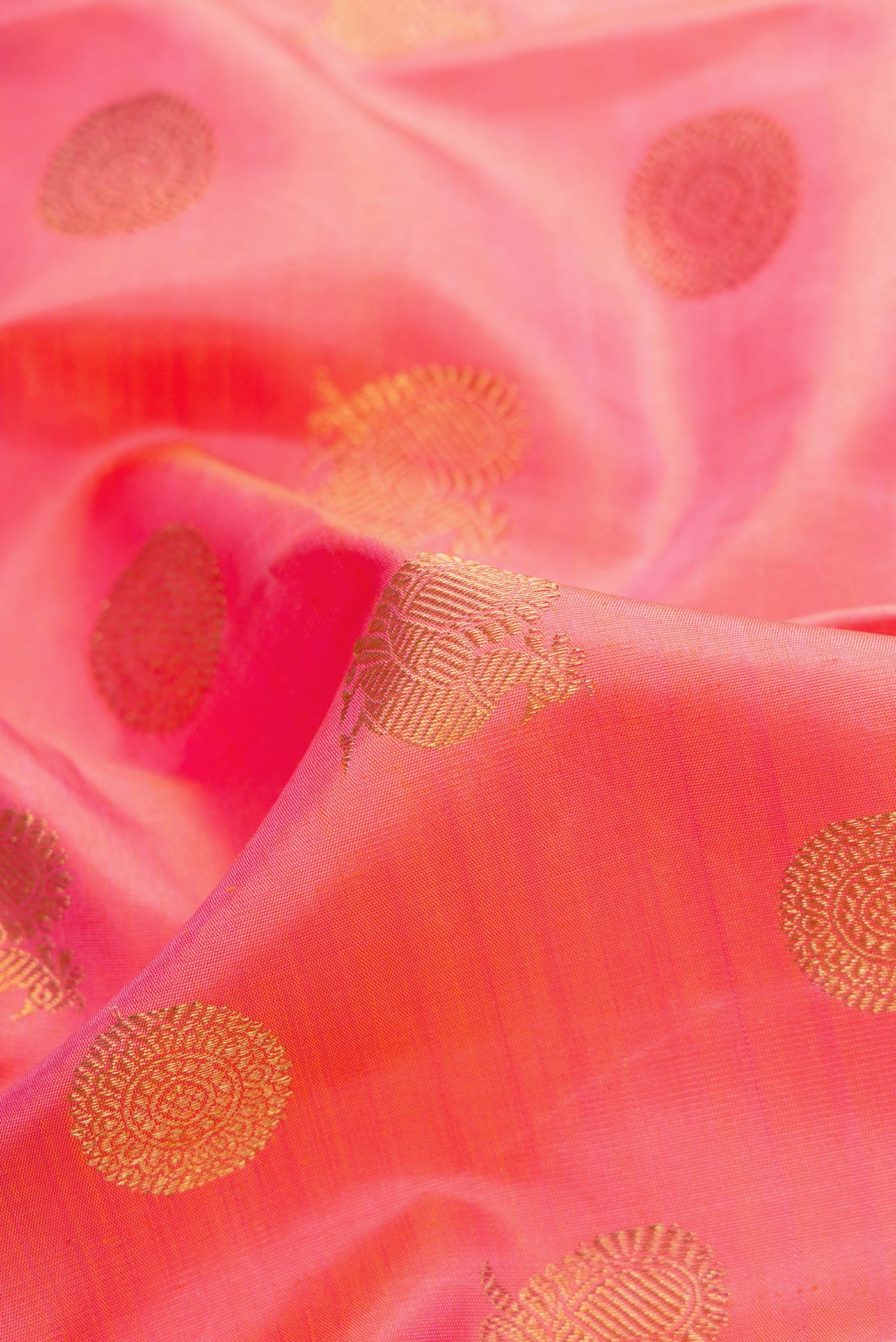 Close up of Pure Silk Pure Zari Pink Dual Tone Kanjivaram Saree with Zari Butta on the body and Zari Border.  displaying folds