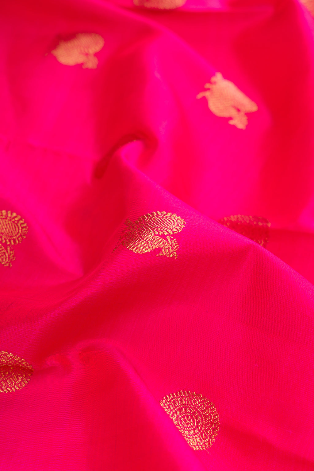 Close up of Pure Silk Pure Zari Dark Pink Dual Tone Kanchipuram Saree with Zari Butta on the body and Zari Border.  displaying folds