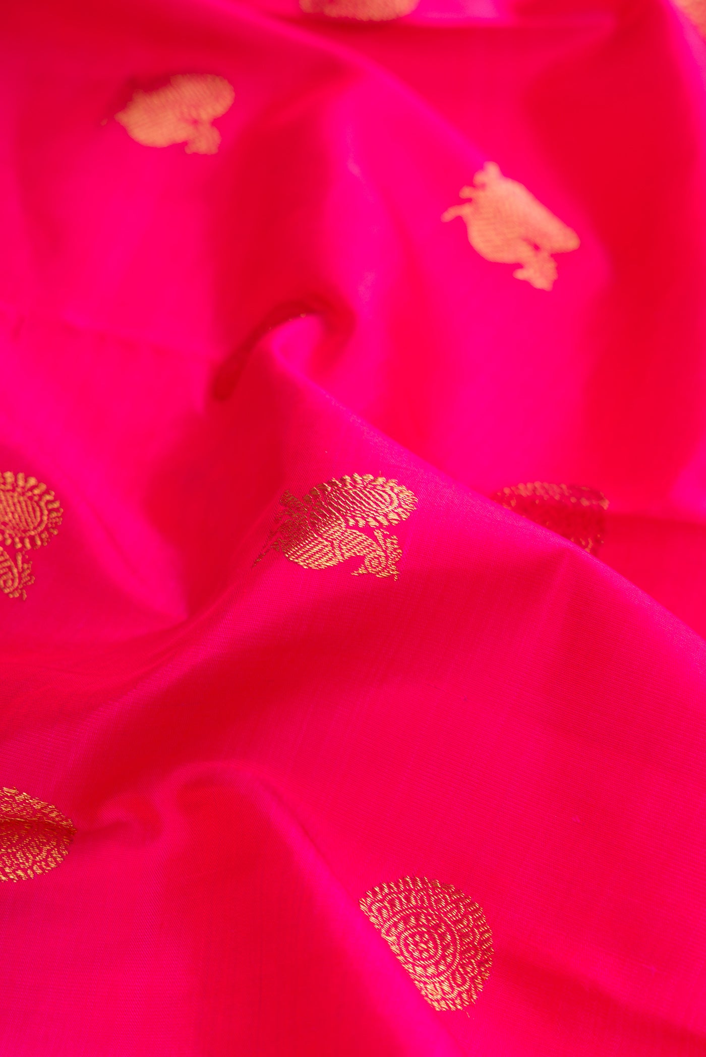 Close up of Pure Silk Pure Zari Dark Pink Dual Tone Kanchipuram Saree with Zari Butta on the body and Zari Border.  displaying folds