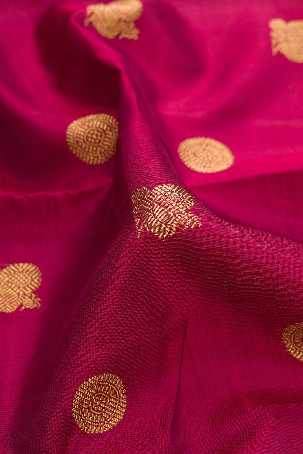 Close up of Pure Silk Pure Zari Maroon Kanjivaram Saree with Zari Butta on the body and Zari Border.  displaying folds