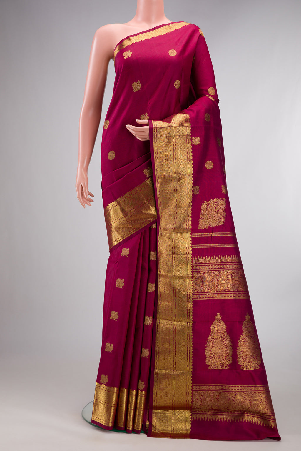 Pure Silk Pure Zari Maroon Kanjivaram Saree with Zari Butta on the body and Zari Border.  displayed on a mannequin