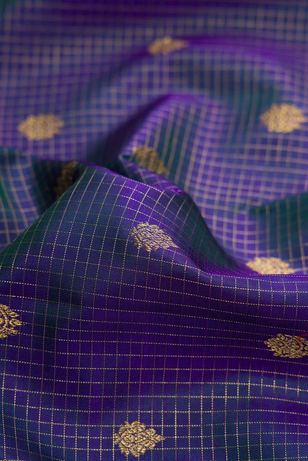 Close up of Pure Silk Pure Zari Peacock Blue Dual Tone Kanchipuram Saree with Checked design on the body and Zari Border displaying folds