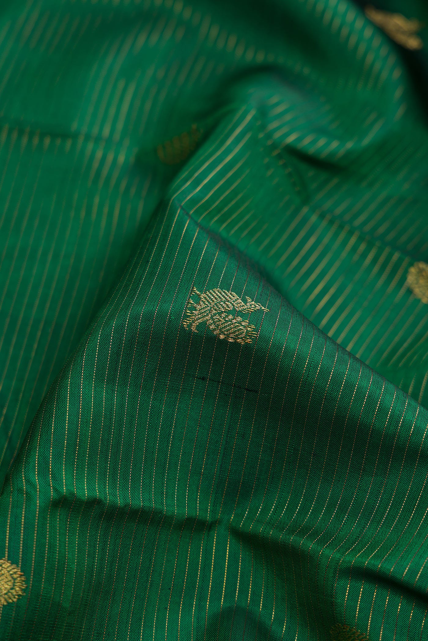 Close up of Pure Silk Pure Zari Bottle Green Kanjivaram Saree with Stripes on the body and Zari Border.  displaying folds