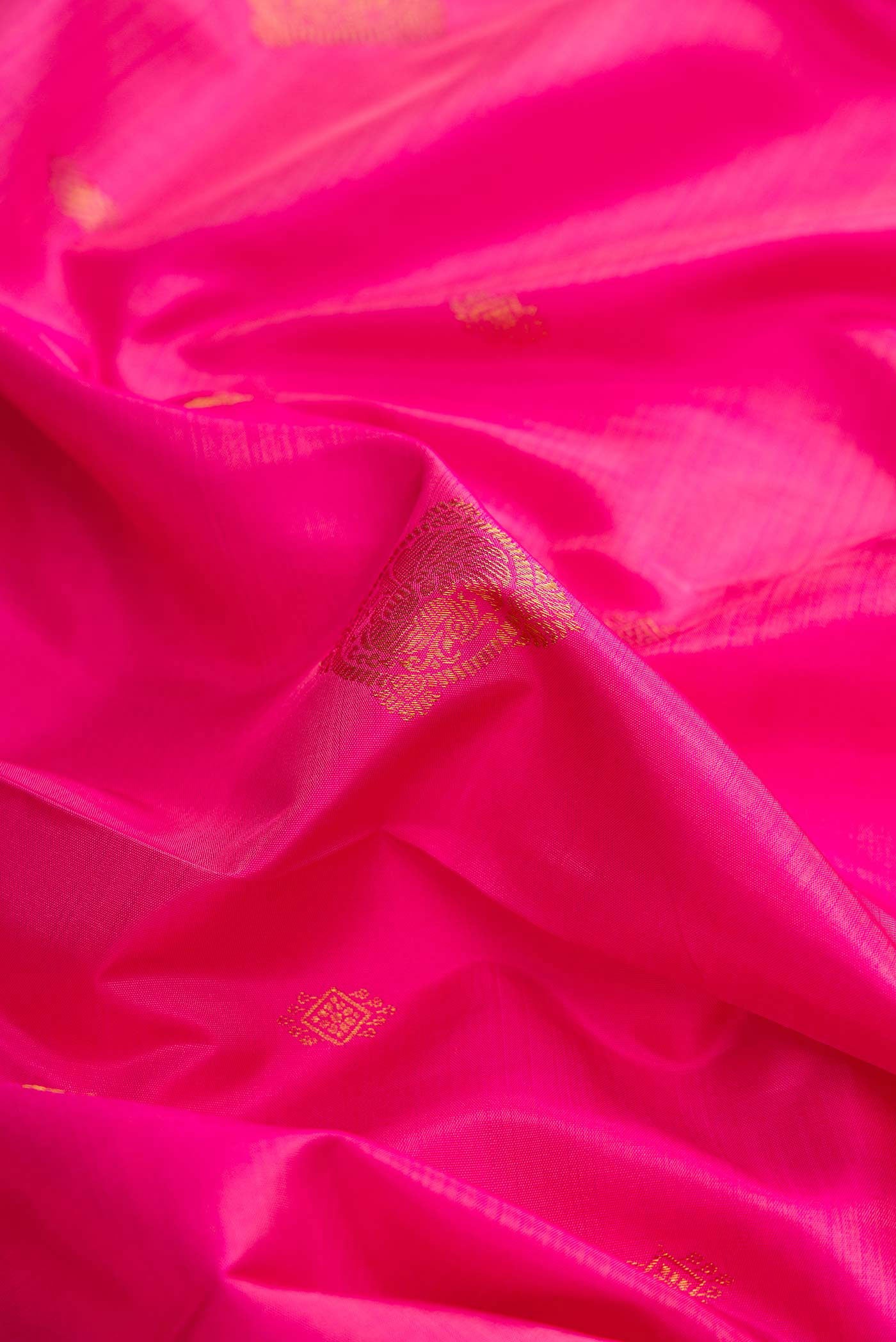 Close up of Pink Kanchipuram Silk Saree with Zari Butta on the body and Zari Border displaying folds