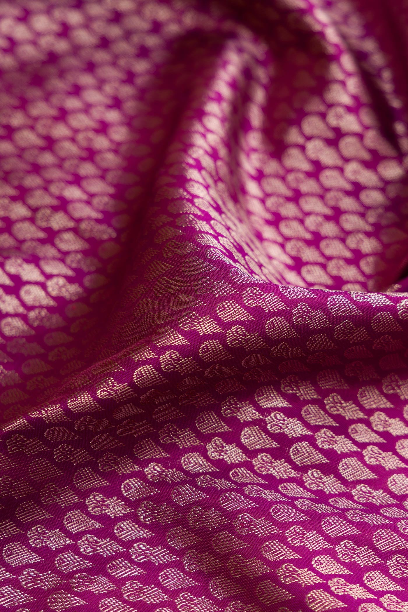 Close up of Magenta Kanchipuram Silk Saree with Zari Brocade on the body and Fancy Border.  displaying folds