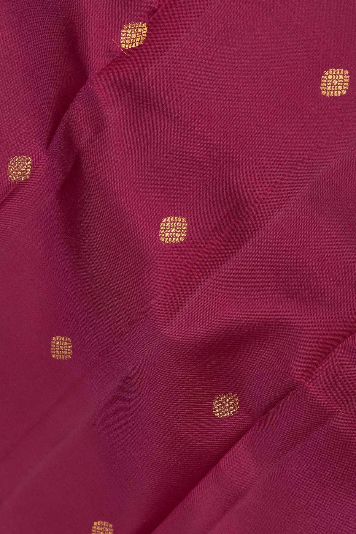 Close up of Magenta Dual Tone Kanchipuram Saree with Zari Butta on the body and Zari And Thread Border displaying folds