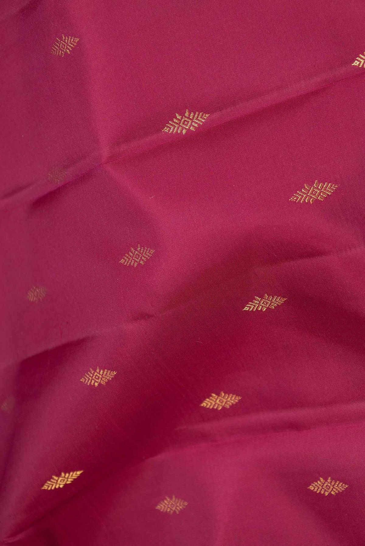 Close up of Magenta Dual Tone Kanchipuram Saree with Zari Butta on the body and Zari Border displaying folds