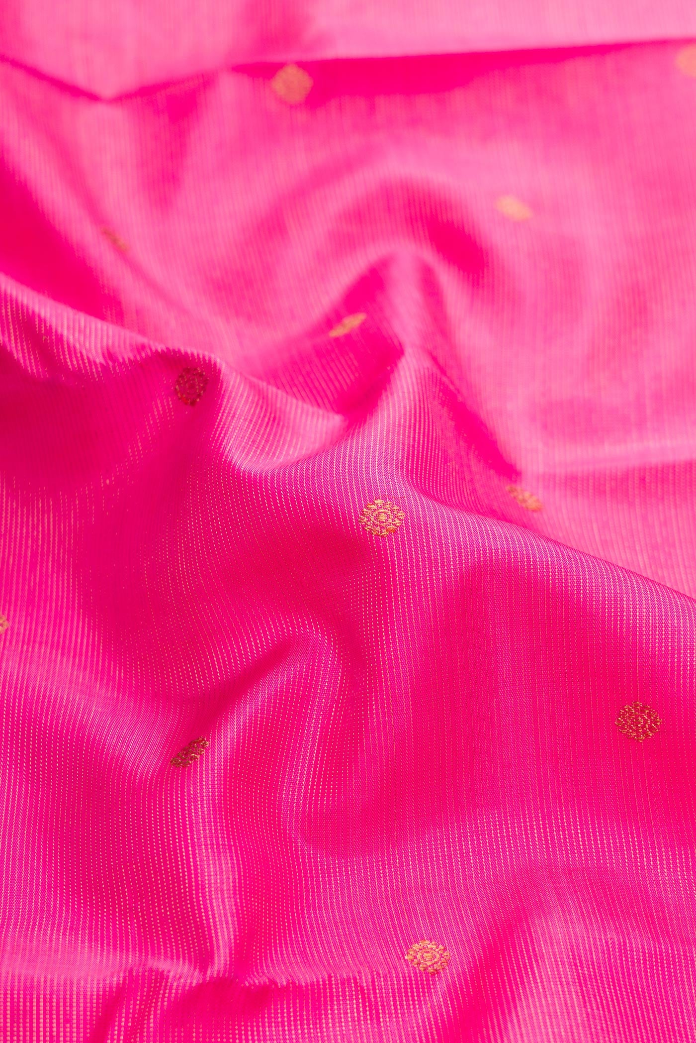 Close up of Pure Silk Pure Zari Pink Dual Tone Kanjivaram Saree with Zari Butta on the body and Zari Border.  displaying folds