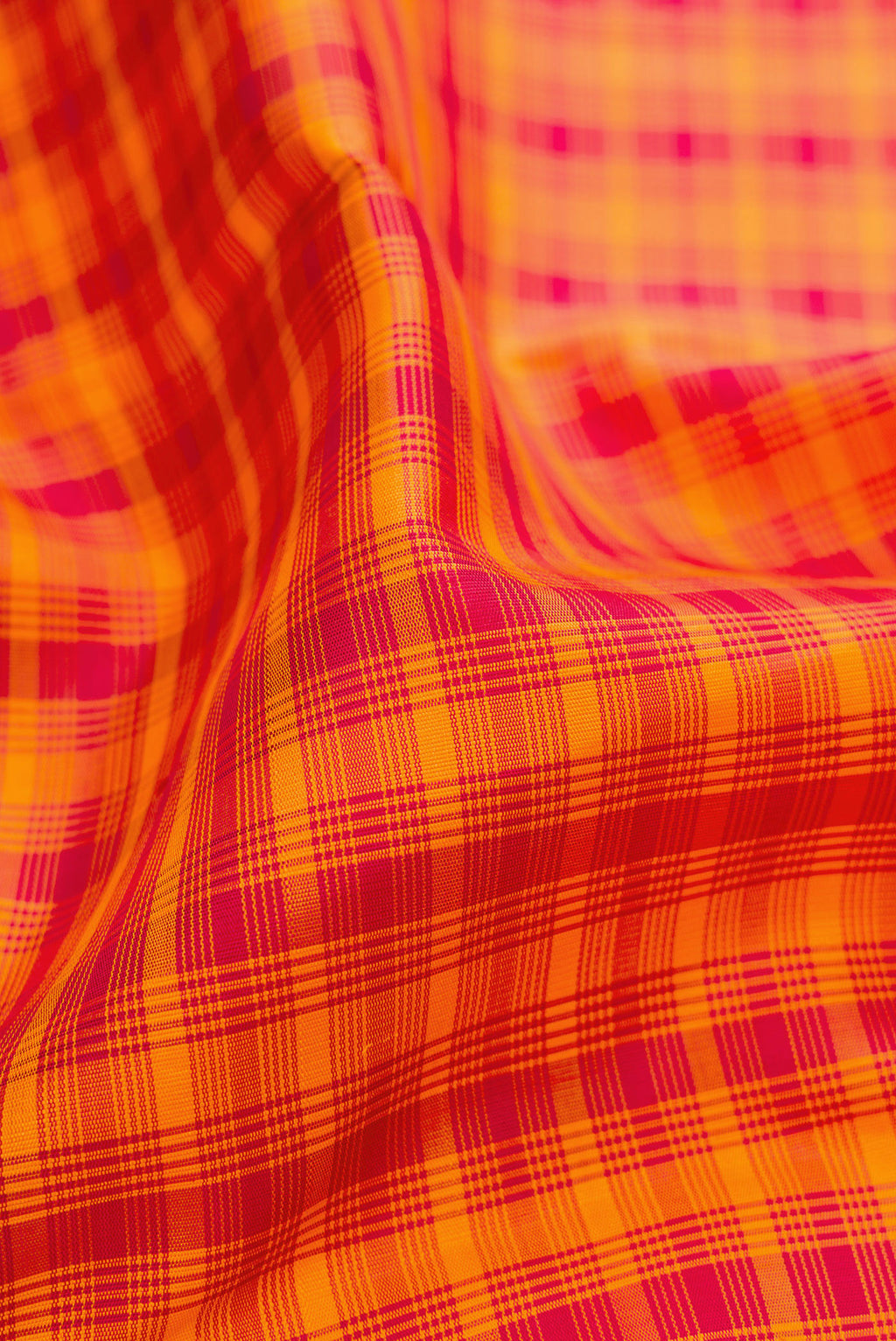 Close up of Orange Kanchipuram Silk Saree with Checked design on the body and Thread Border.  displaying folds