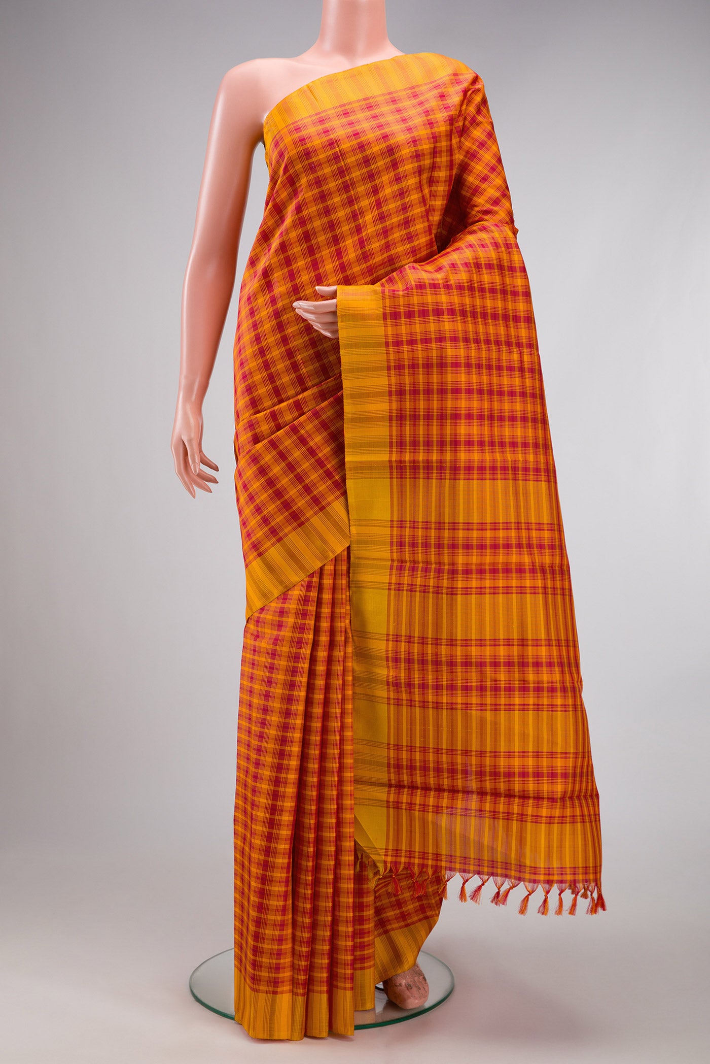 Orange Kanchipuram Silk Saree with Checked design on the body and Thread Border.  displayed on a mannequin