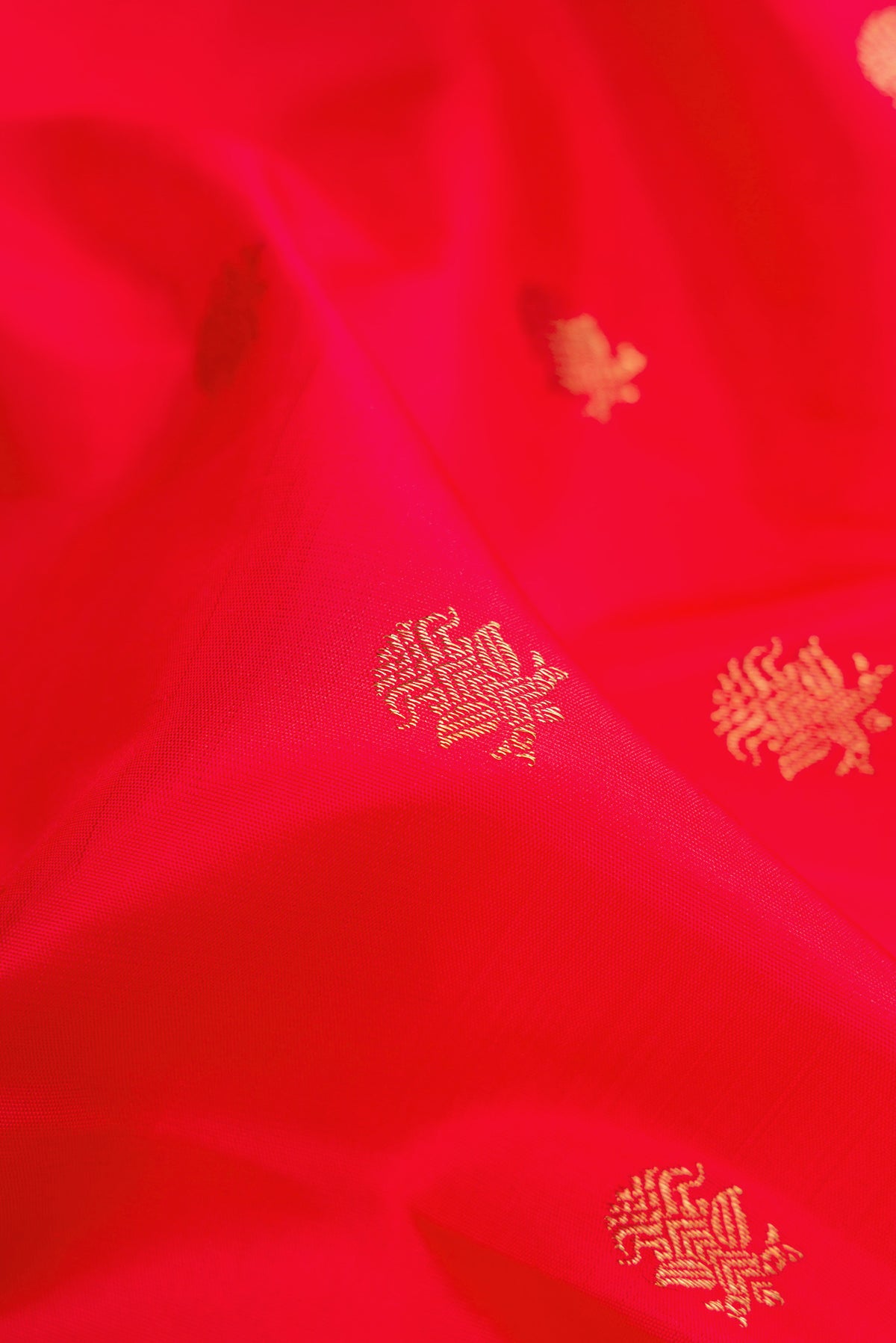 Close up of Red Dual Tone Kanchipuram Silk Saree with Zari Butta on the body and Zari Border.  displaying folds
